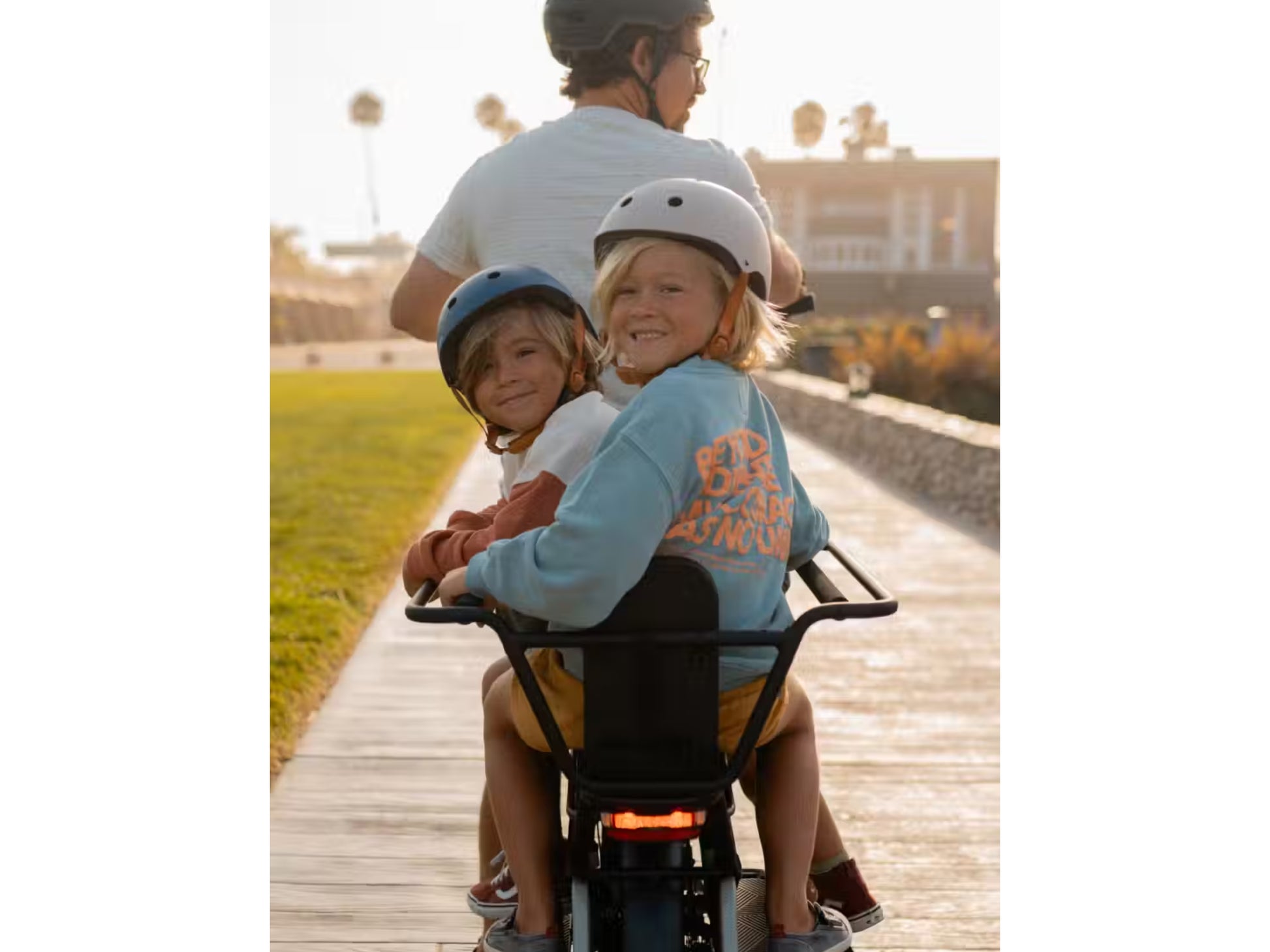 Aventon Abound Male rider with two kiddos in the cargo accessory option