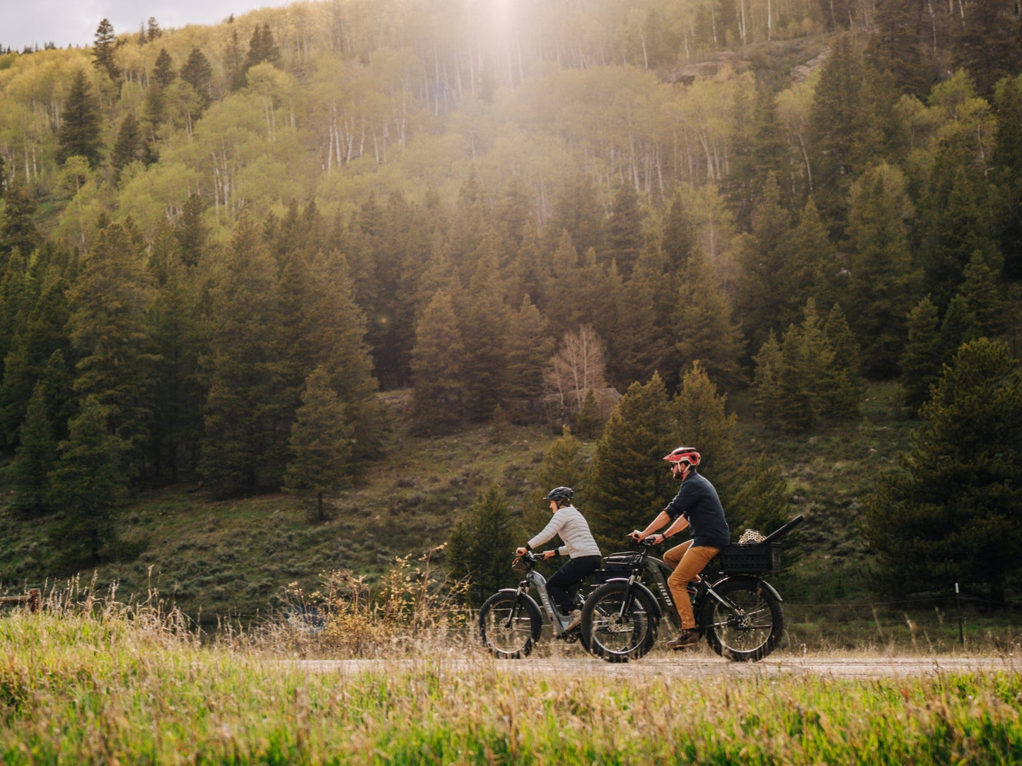 Aventon Aventure 3 Hardtail All Terrain Electric Bike Man and Woman riding on forest trail. Optional accessories shown