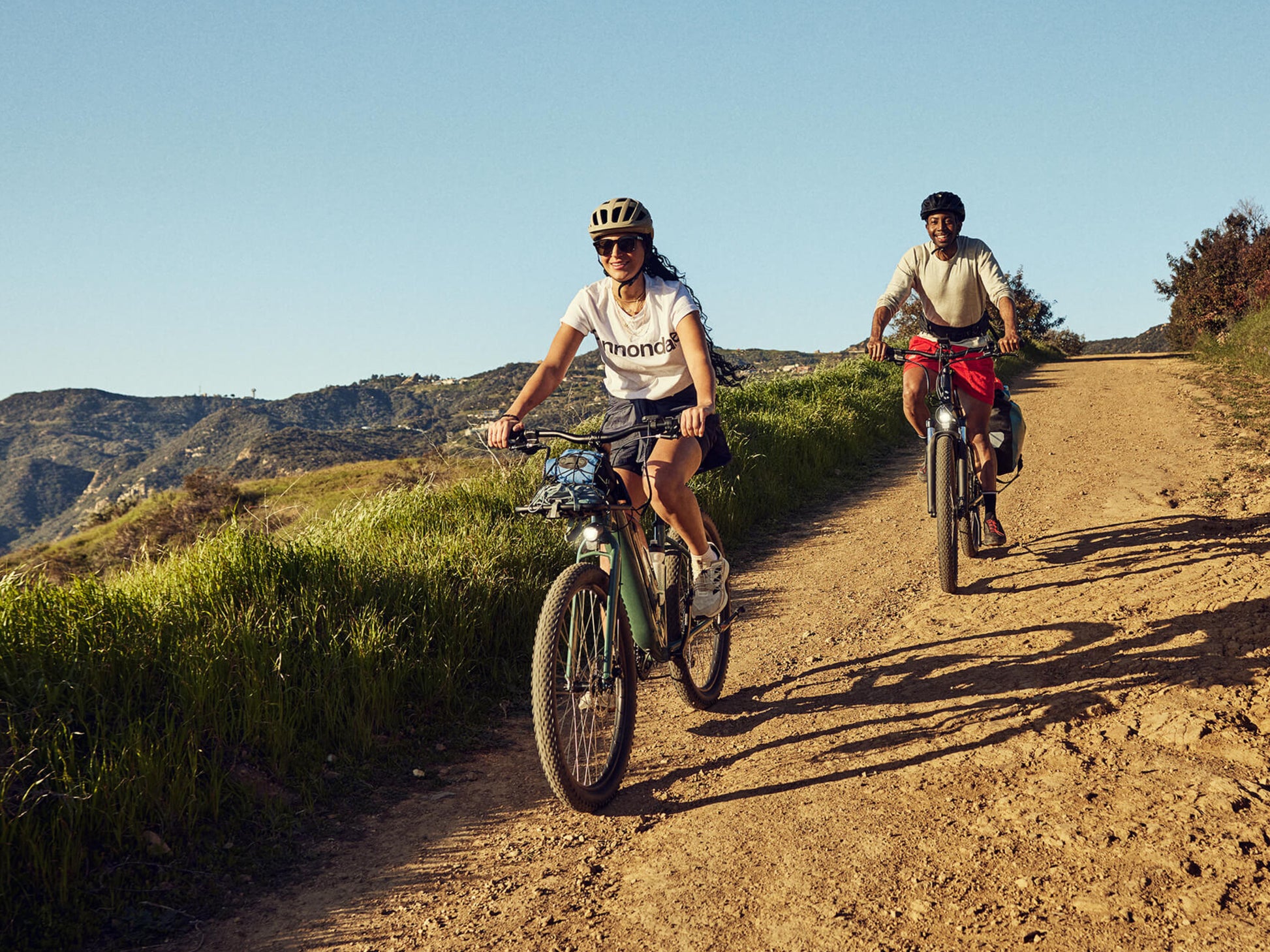 Cannondale Adventure Neo Allroad Low Step-Thru Road/commuter Two riders on hard packed dirt path thru rolling hills