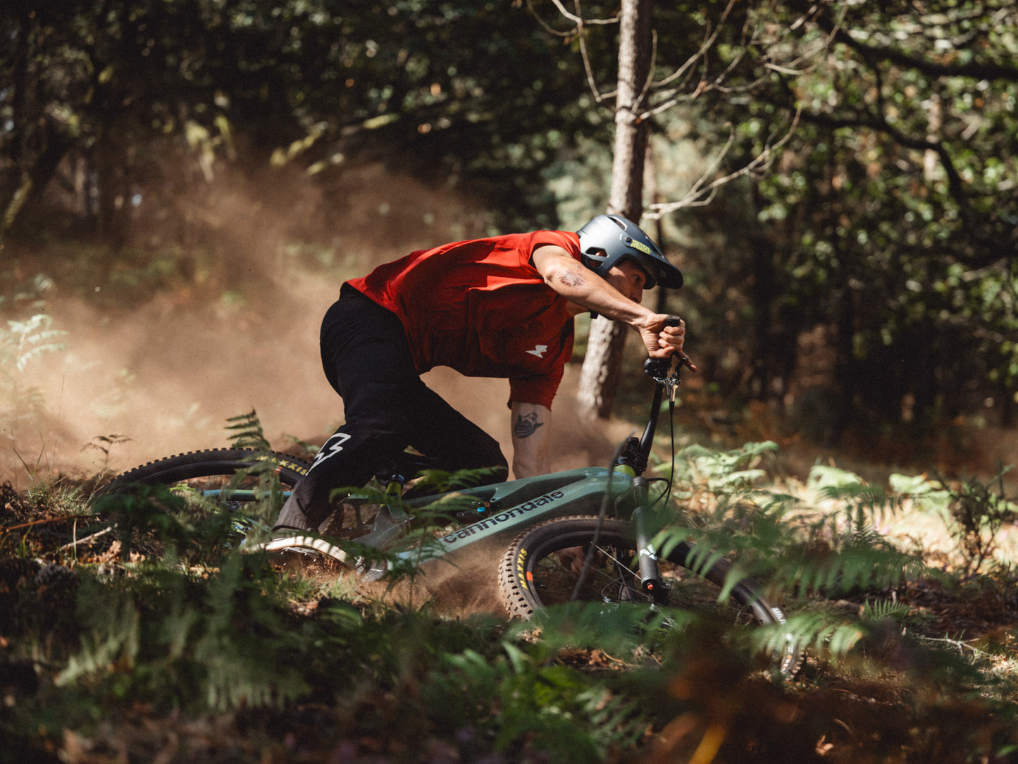 Cannondale Moterra SL Dual suspension eMTB Rider laying it sideways in forest setting