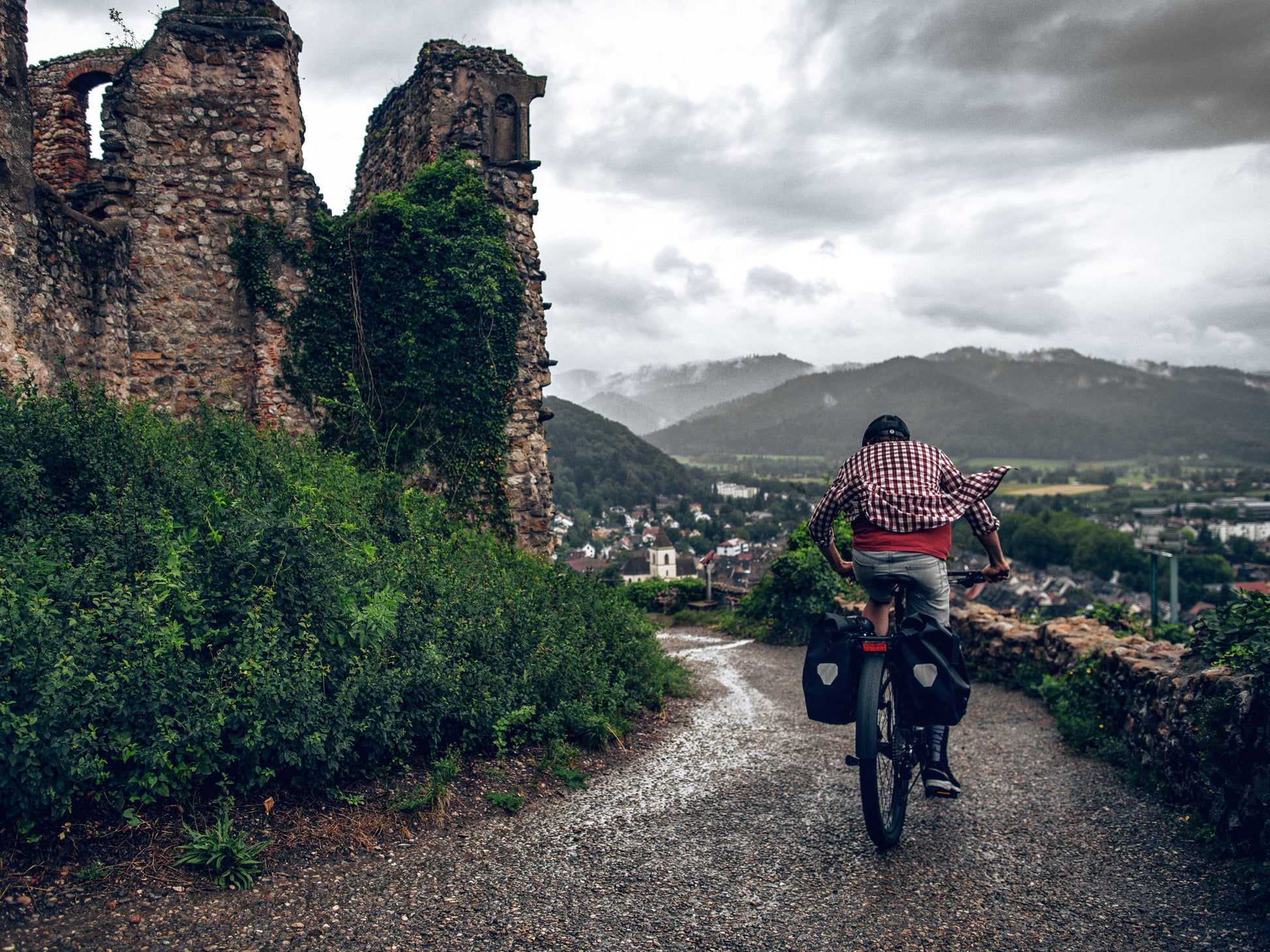 Cannondale Tesoro X Electric Bike High Speed Road / commuter Rider on cobble path in European city with grey skies overhead