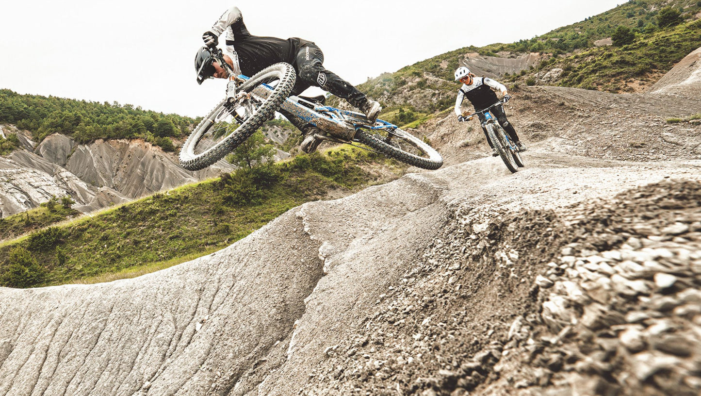 Mondraker Neat Riders jumping and riding on gravel trail / dirt track
