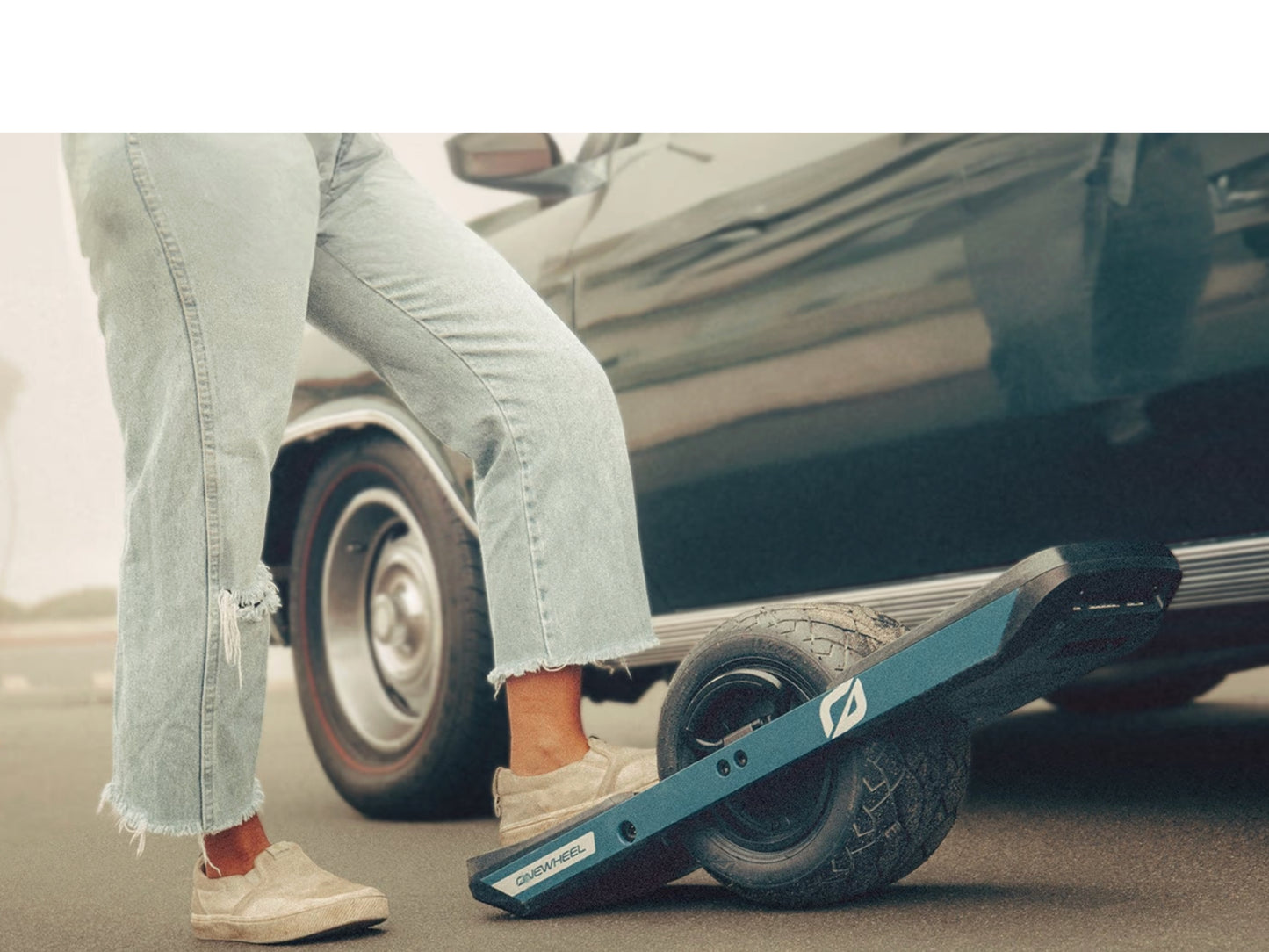 OneWheel XR Classic Electric Board Powder blue Rider with foot on the board paused by a car