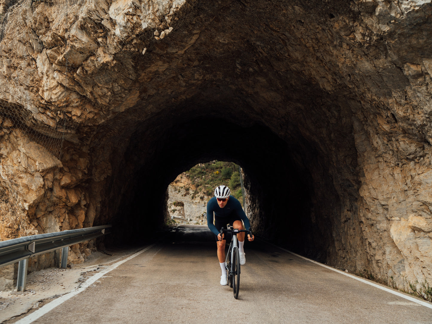 Orbea Gain Gravel road ebike. Rider on paved path traveling through tunnel.
