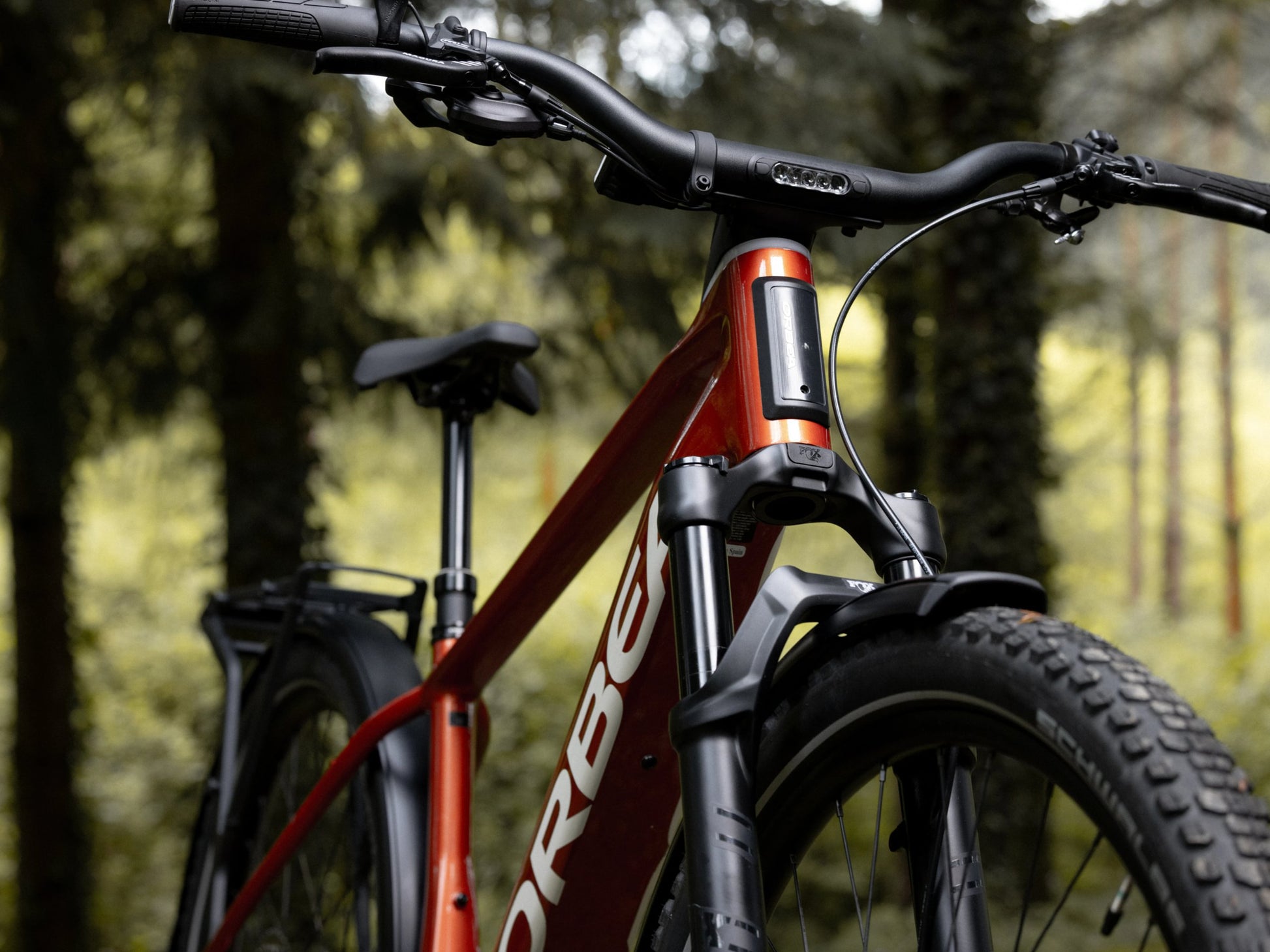 Orbea Kemen ADV 30 Mars red / white gloss Lifestyle Closeup of handlebars, stem, fork in a forest setting