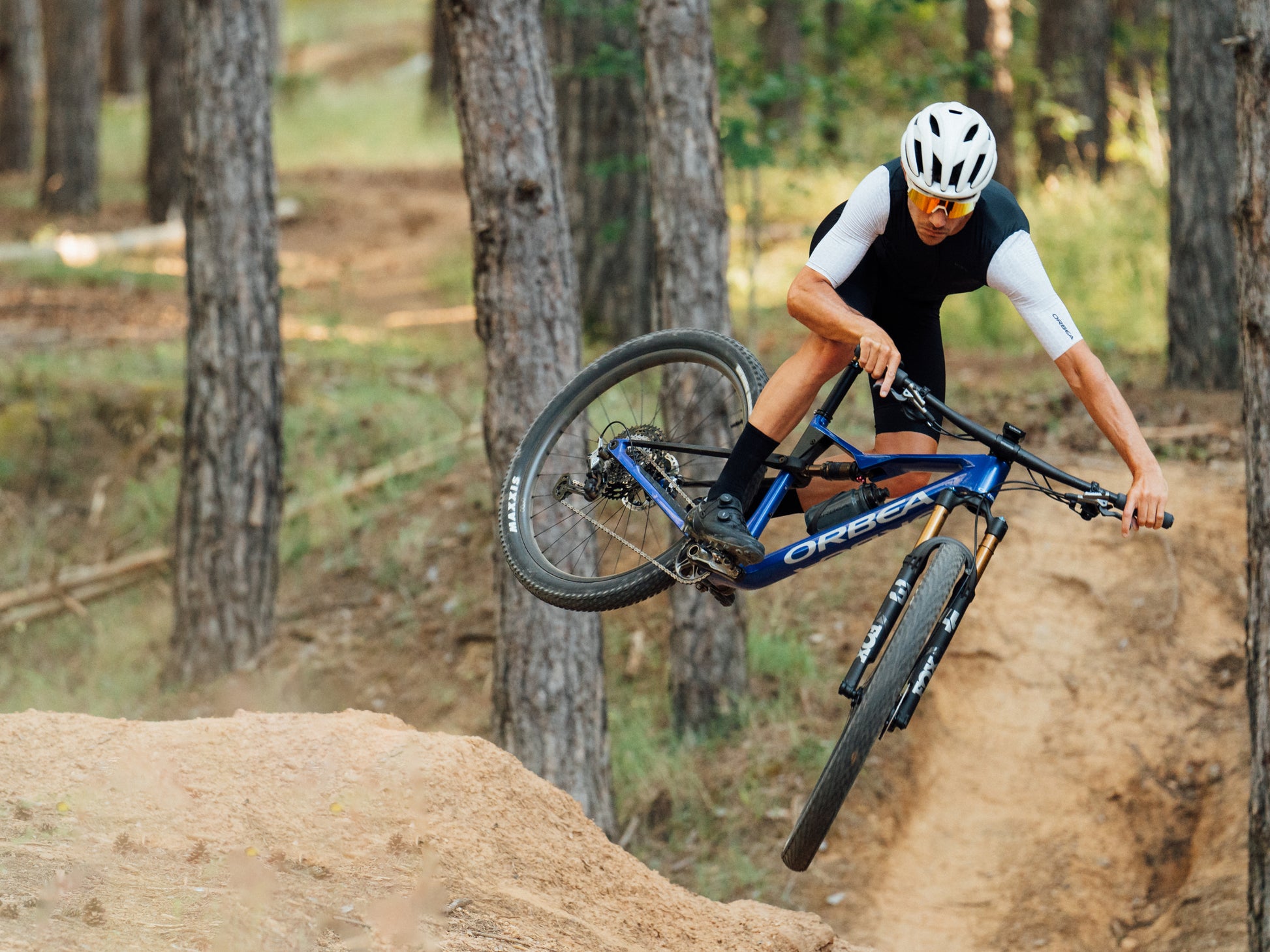 Orbea Oiz Full Suspension Mountain bike Rider catching air in forest setting