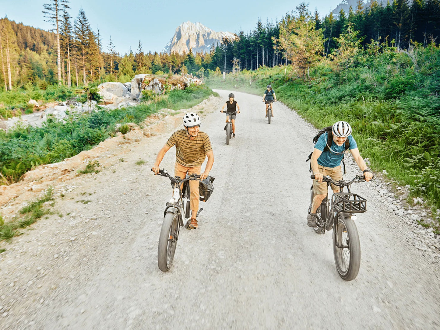 Rad Power RadRover™ 6 Plus Electric Fat Tire Bike Step-Thru Group Ride on dirt path surrounded by greenery with a mountain in the background