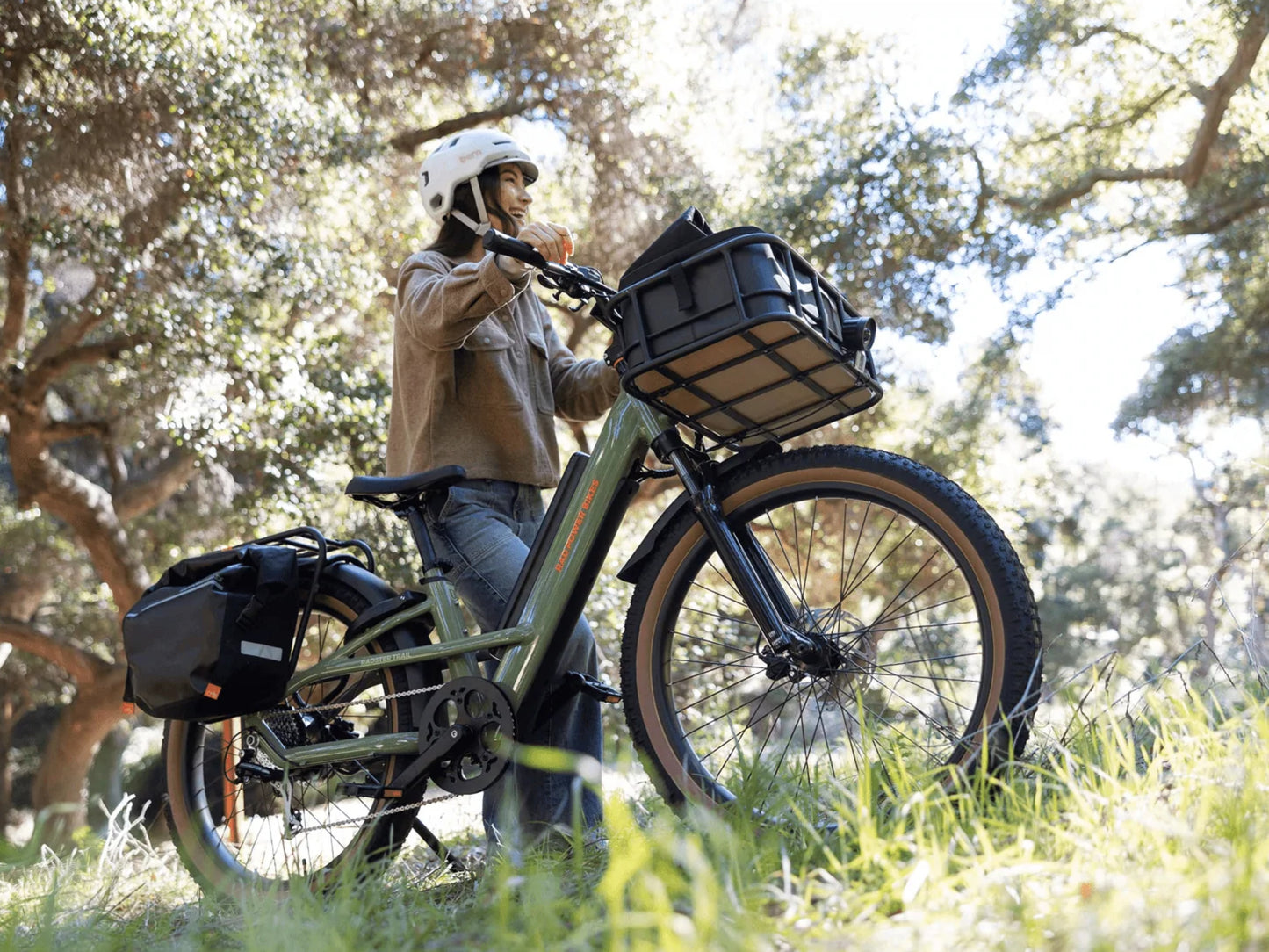 Rad Power Radster™ Trail Electric Off-Road Bike Fir green. Woman stopped offroad amongst the trees