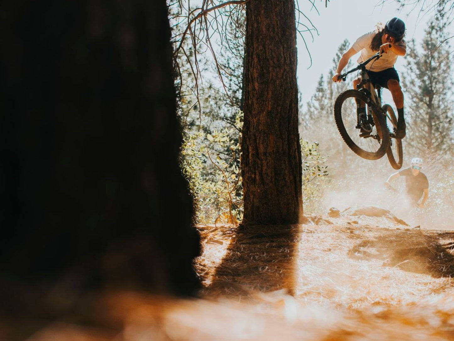 Specialized Epic 8 EVO Full suspension Mountain bike Riders on forest single track. Front rider getting big air