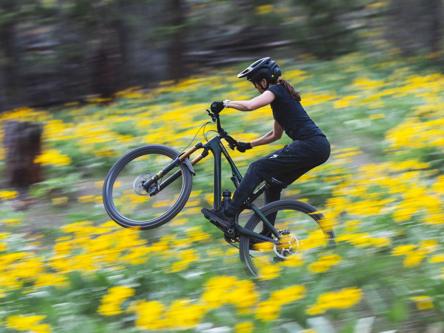 Specialized Stumpjumper Full Suspension Mountain bike. Rider getting air in a field of yellow flowers.