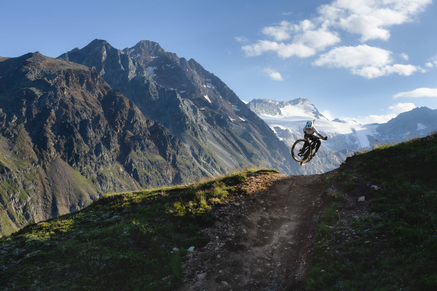 Specialized Turbo Levo SL 2 Pro Full suspension eMTB Rider catching air on dirt trail with snowy mountain background