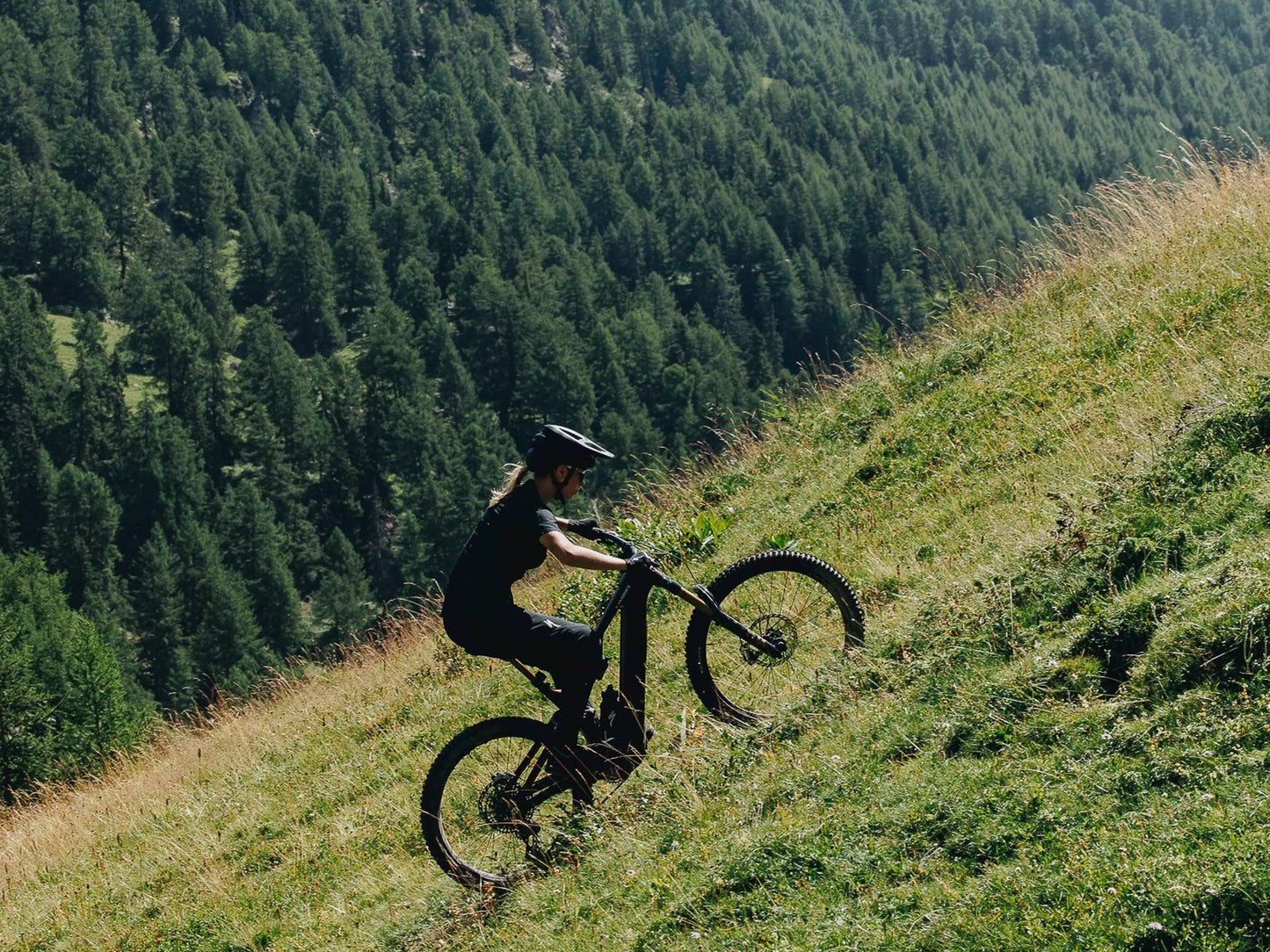 Specialized Turbo Levo S-Works Full suspension eMTB Rider climbing green grassy hill