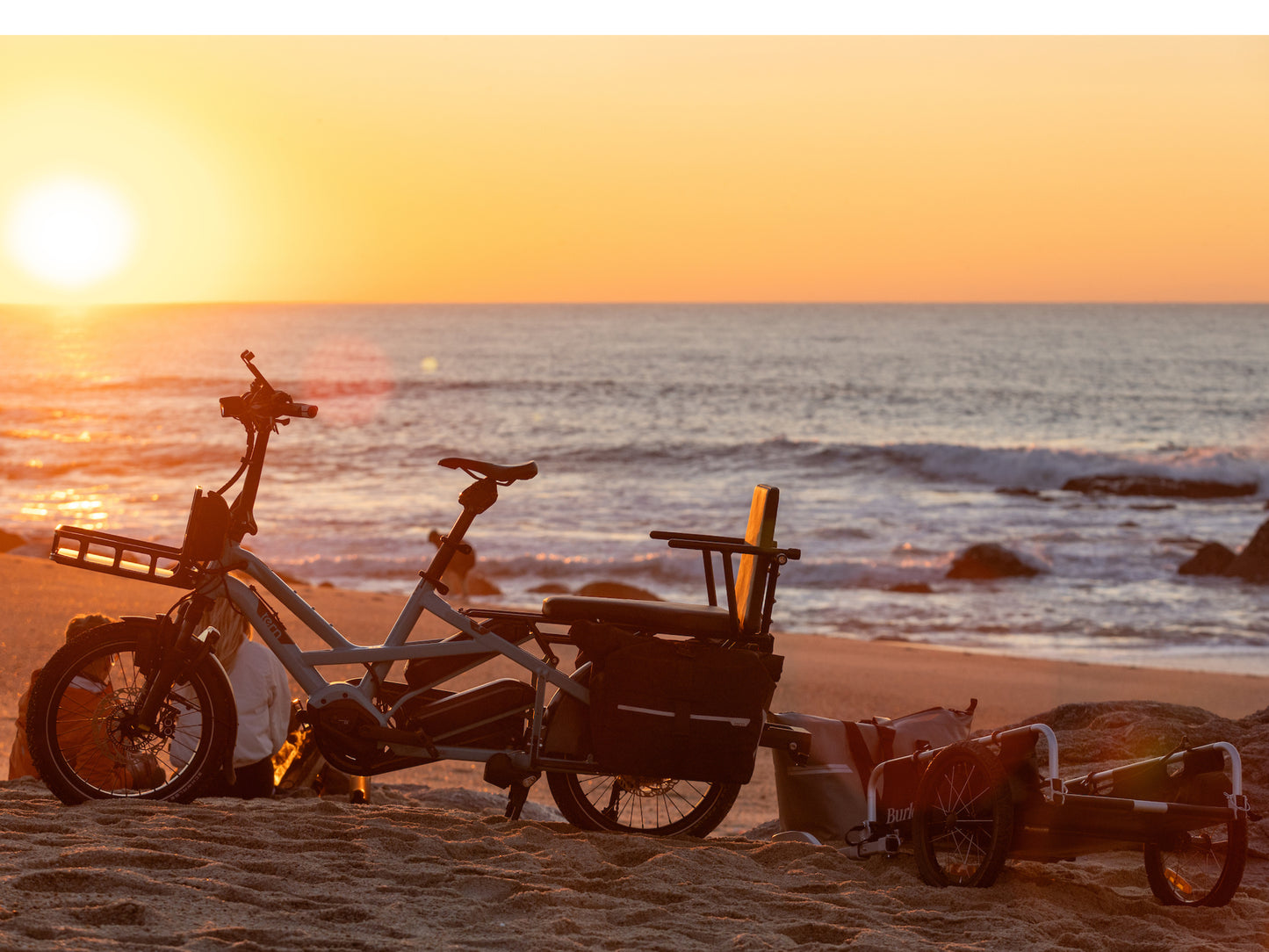 Tern GSD Lifestyle. Bike parked in the sand watching the sunset over the ocean. Multiple accessories shown
