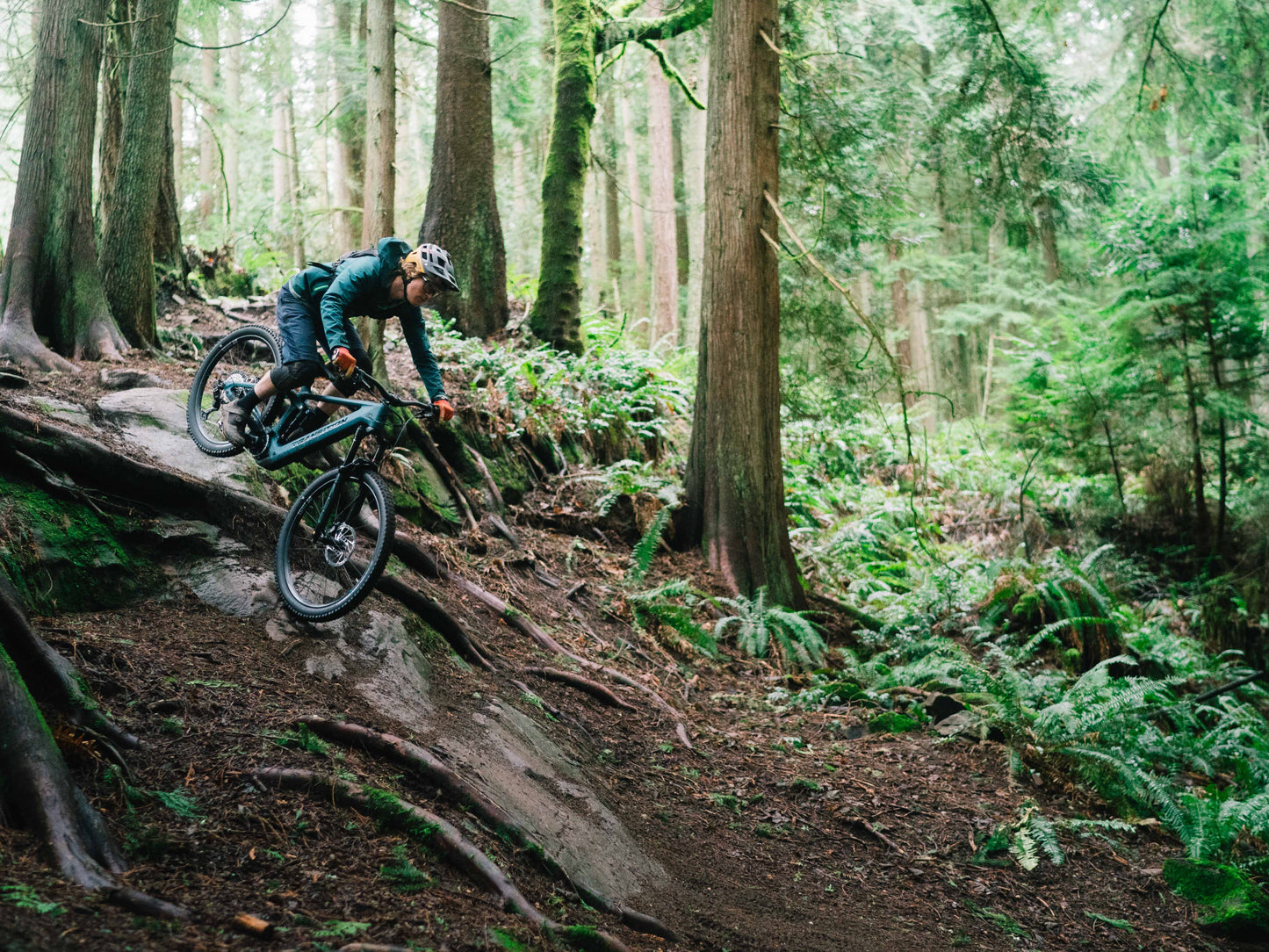 Transition Regulator CX Carbon Full suspension eMTB Salish sea blue Downhill rider on forest trail