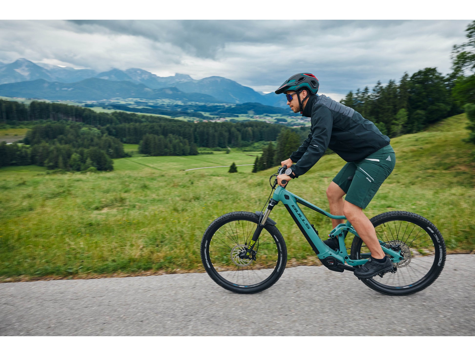 Bulls Copperhead EVO AM 2 750 eMTB full suspension man riding on road with mountains in background