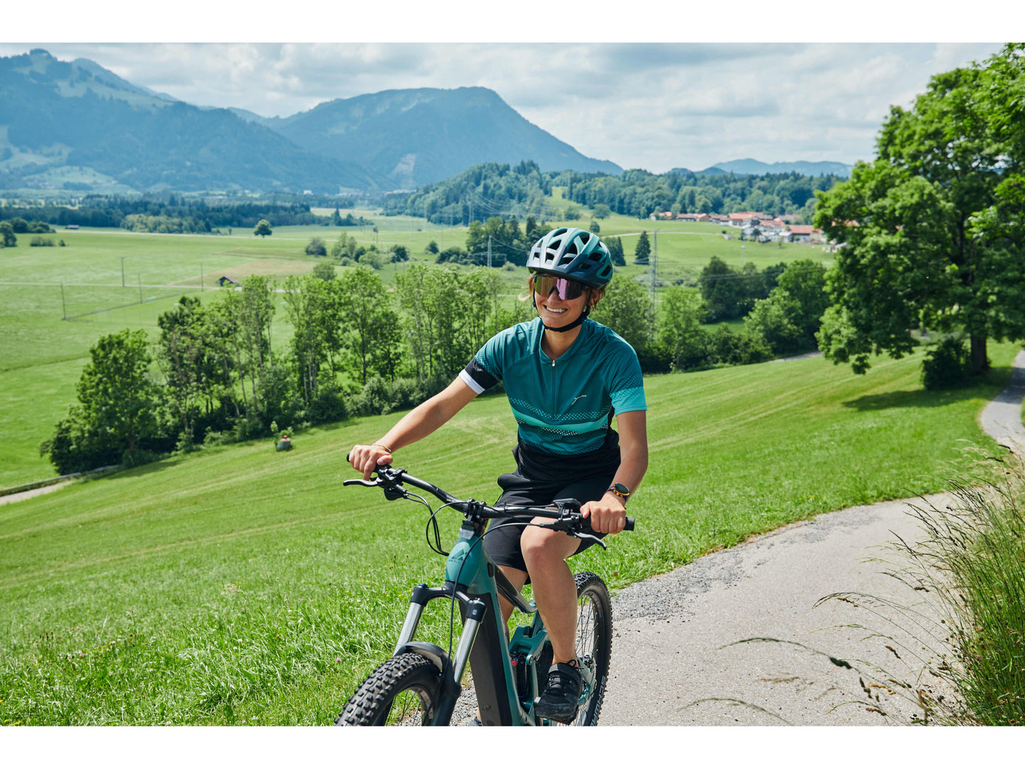 Bulls Copperhead EVO AM 2 750 eMTB full suspension woman riding on road with mountains in background