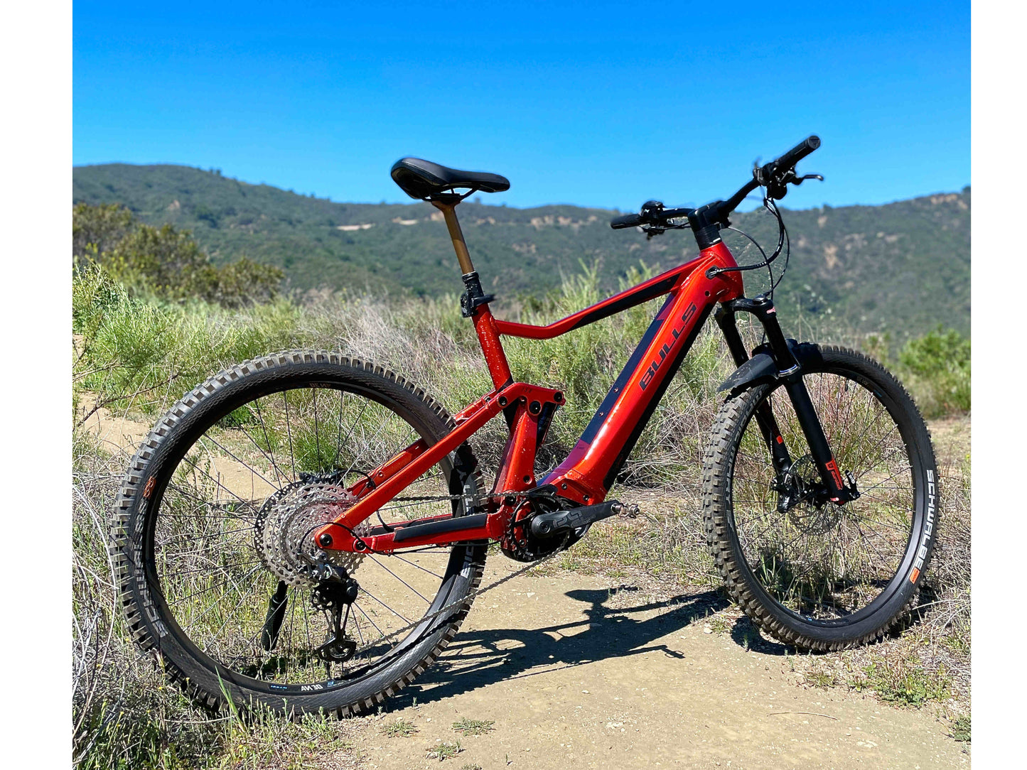 Bulls Copperhead EVO AM 4 750 eMTB full suspension metallic orange black matte rear right side profile on mountain trail