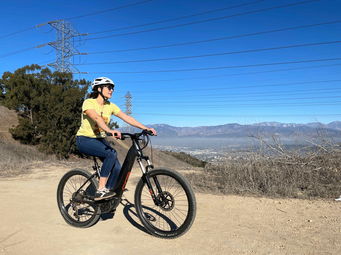 Bulls Copperhead EVO HD 750 Wave eMTB hard tail woman riding trail with city in background