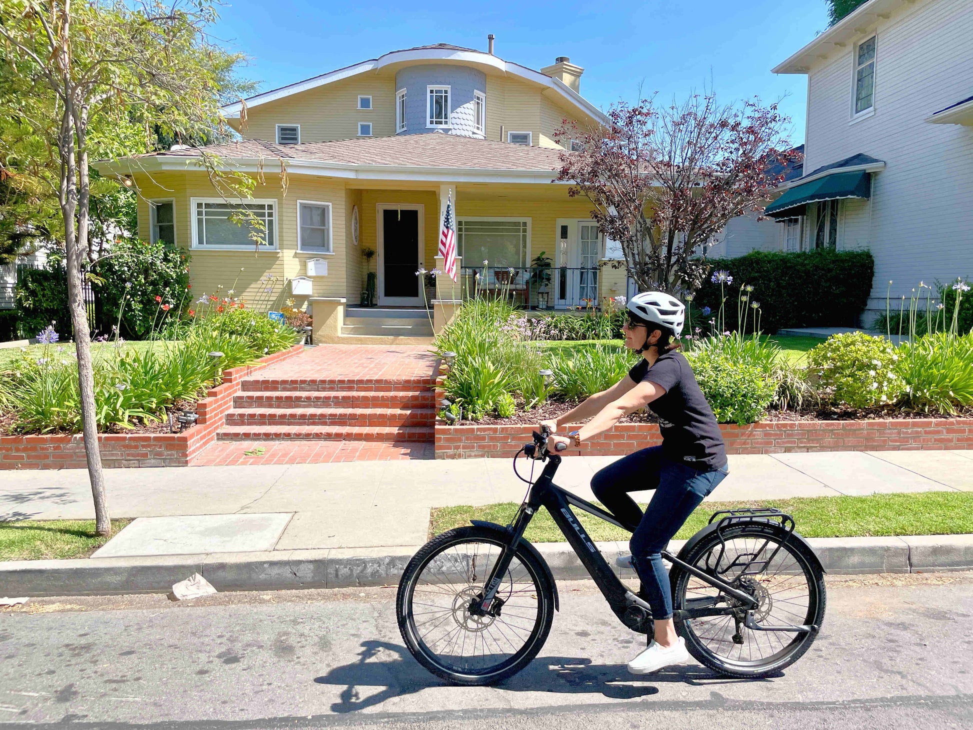 Bulls Iconic EVO TR 1 750 eMtb full suspension lady riding city street with neighborhood in background