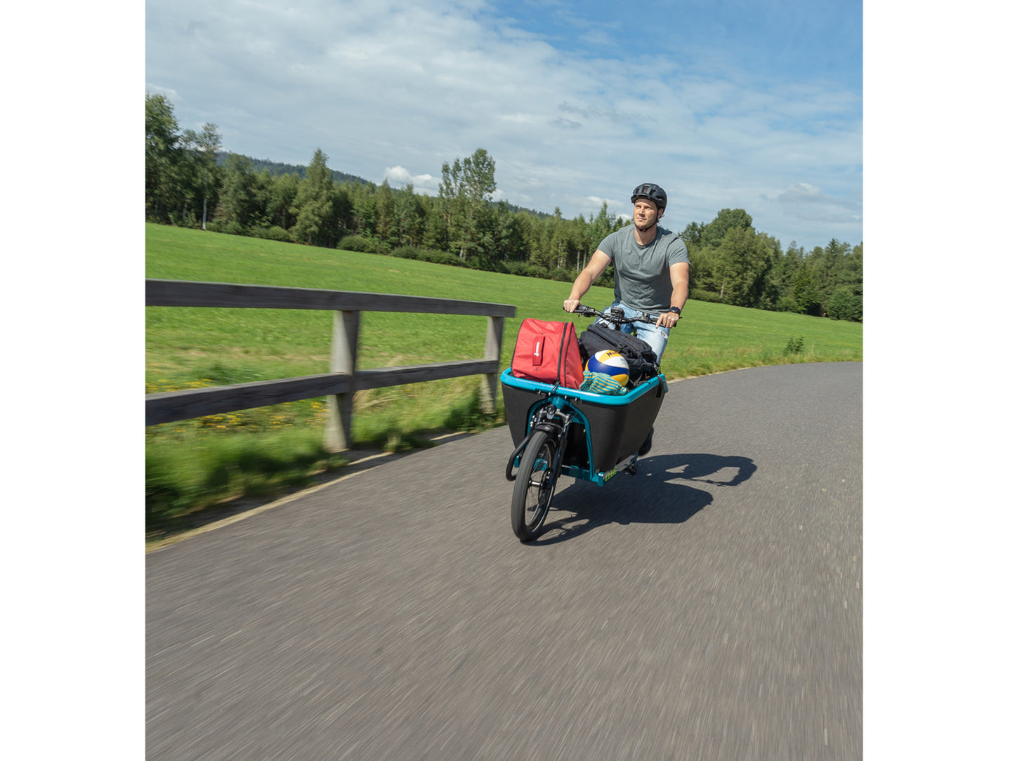 Cube Cargo Sport Hybrid 500 eMTB man riding country road with luggage in cargo area