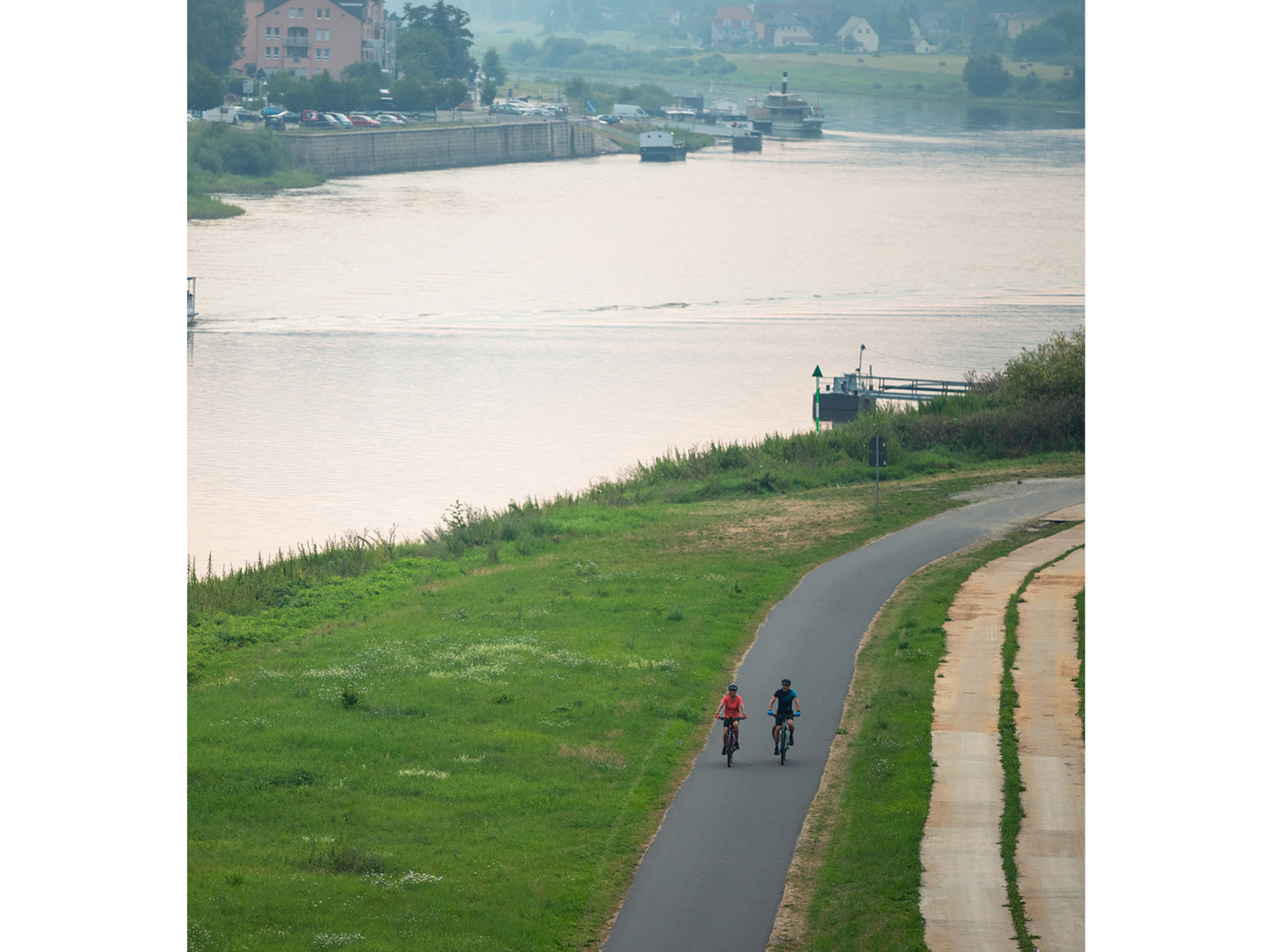 Cube Kathmandu Hybrid One 625 eMTB hardtail couple riding bike path along river