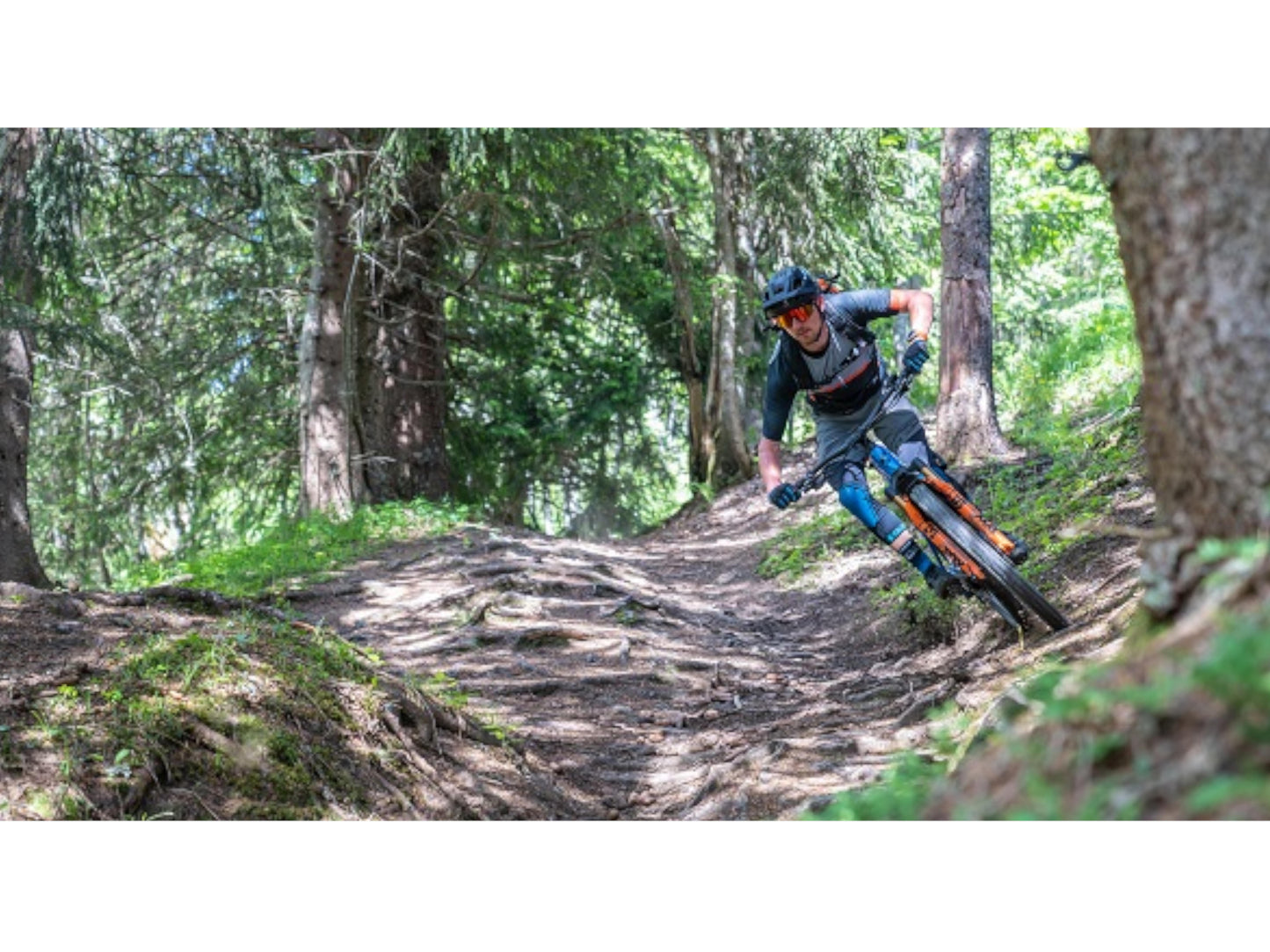 Cube Stereo Hybrid 140 HPC SLX 750 eMTB full Suspension man riding down forest single track trail