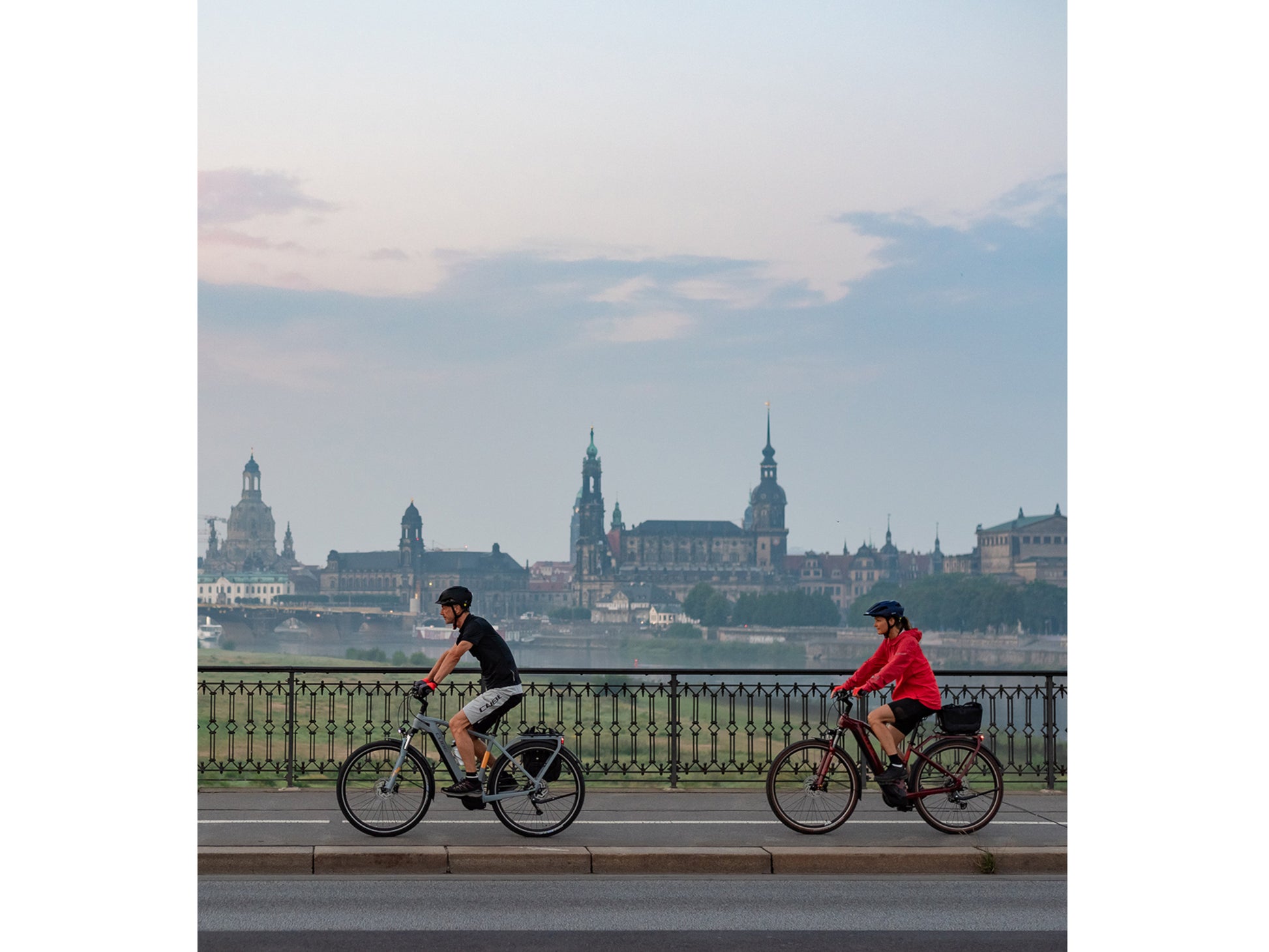 Cube Touring Hybrid ONE 500 Easy Entry eMTB hardtail two people riding on roadside path with city in background