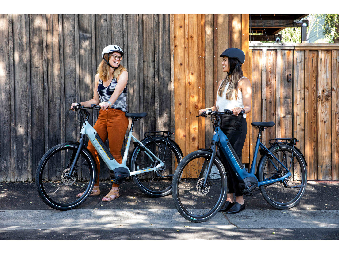Gazelle Ultimate C380 Low Step eMTB hard tail two women standing with bikes city sidewalk