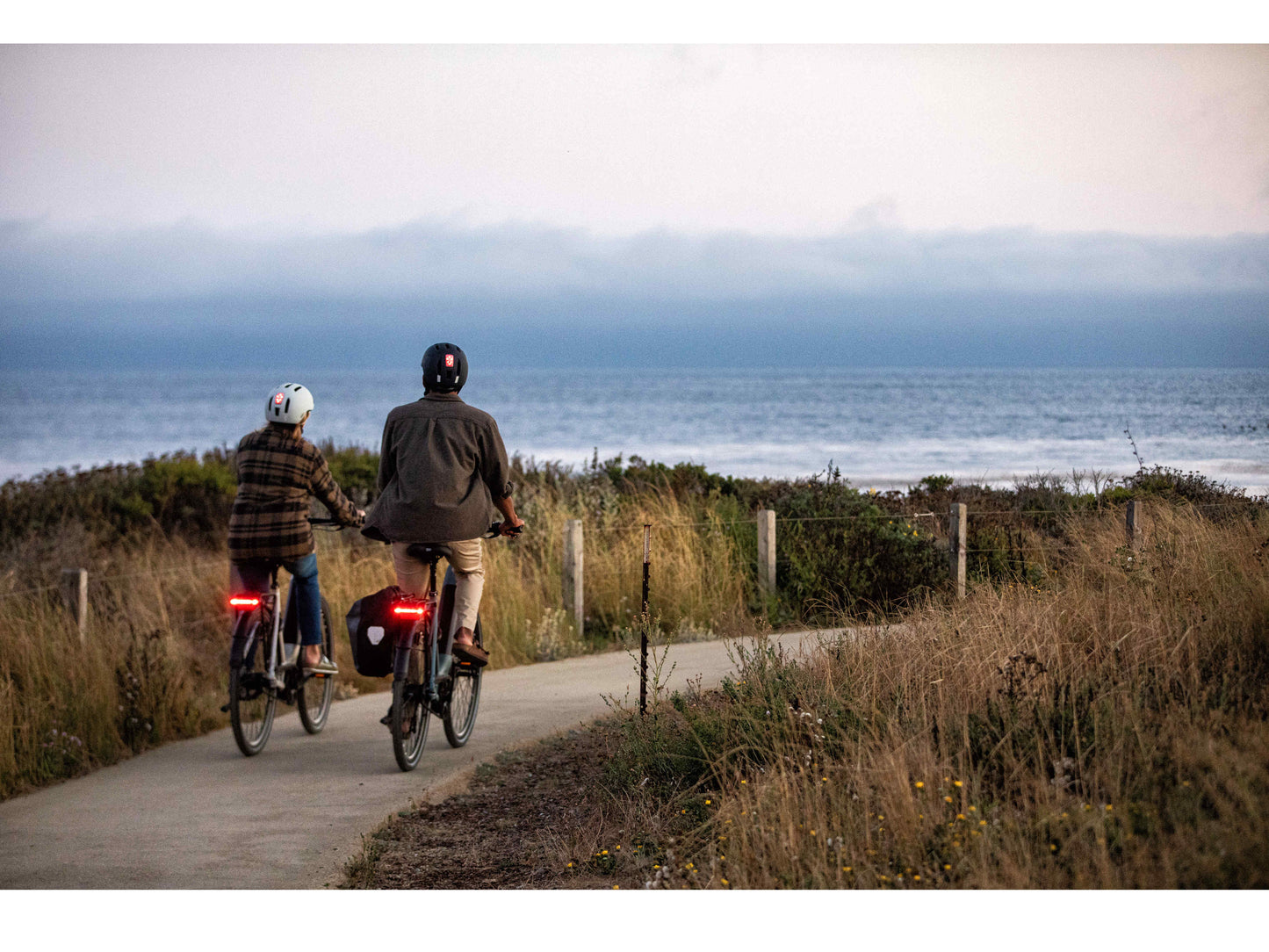 Gazelle Ultimate C8 Low Step action photo of couple riding by beach on bike path