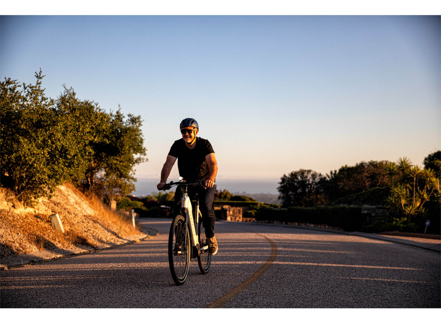 Gazelle Ultimate T10 High Step dust light matte action photo of man riding on ebike in country side