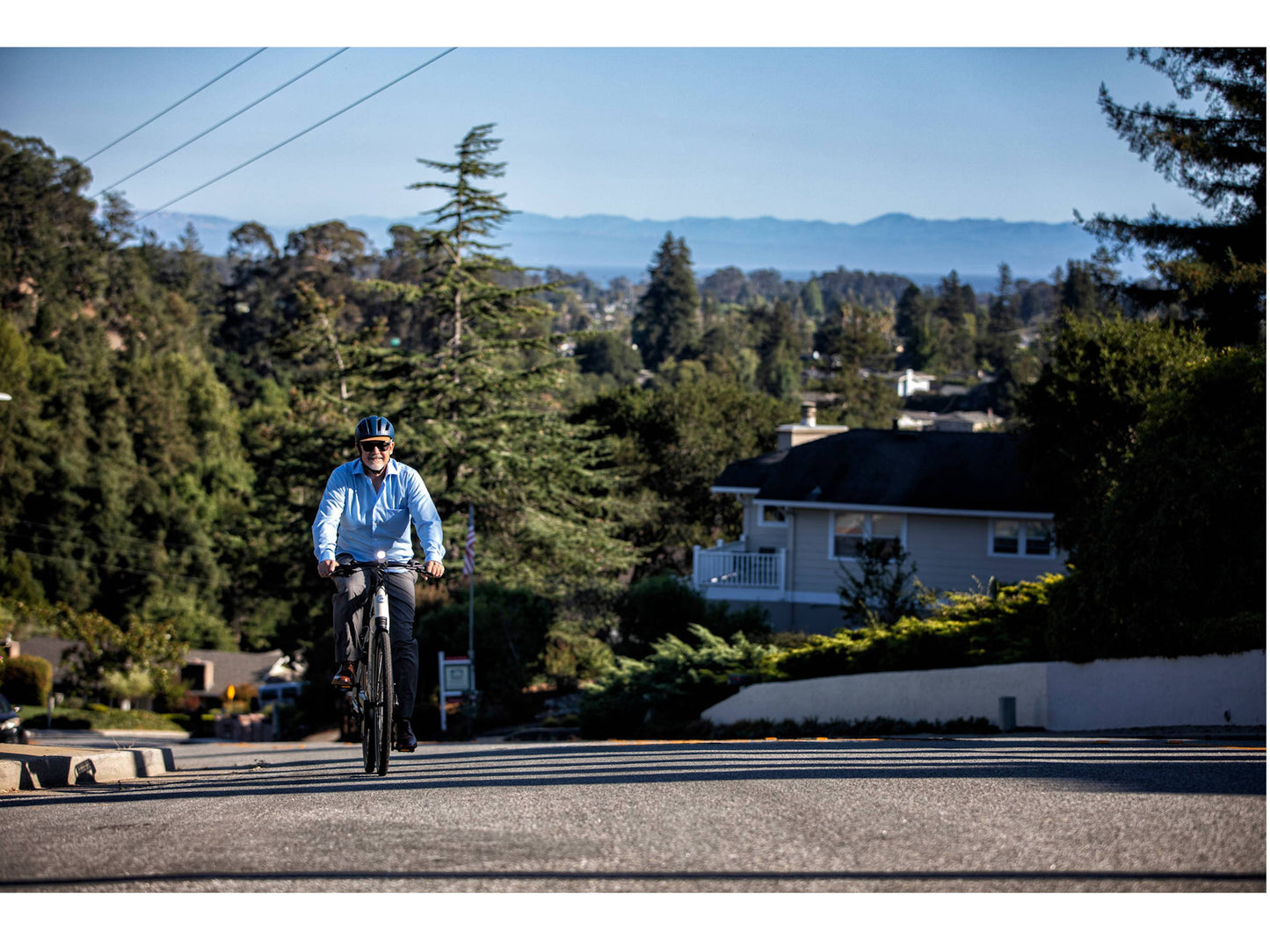 Gazelle Ultimate T10 High Step dust light matte action photo of man riding on city street uphill