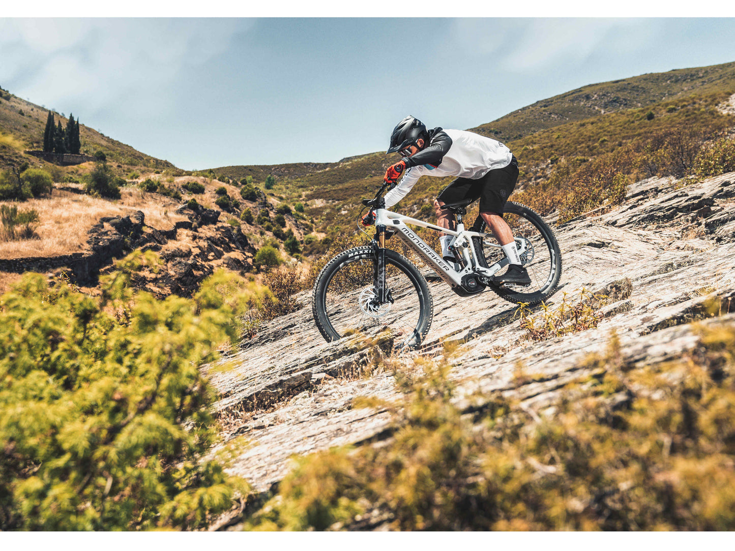 Mondraker Crafty Carbon R eMTB full suspension racing desert grey orange man riding down technical single track