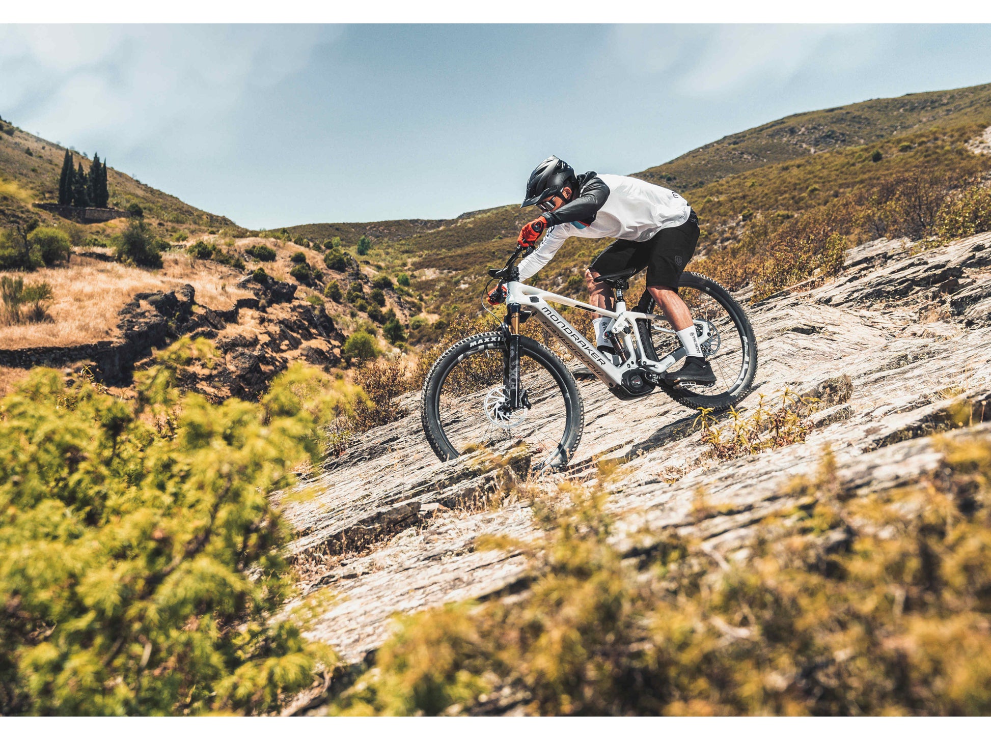 Mondraker Crafty Carbon R eMTB full suspension racing desert grey orange man riding down technical single track