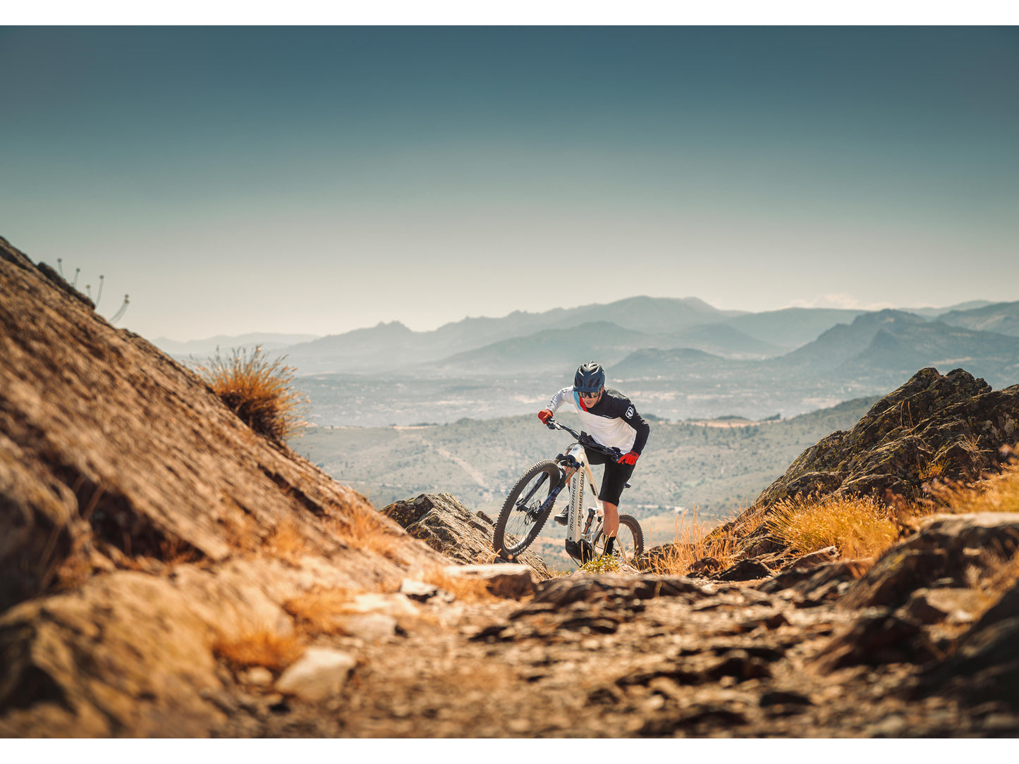 Mondraker Crafty Carbon R eMTB full suspension racing desert grey orange man riding up rocky trail