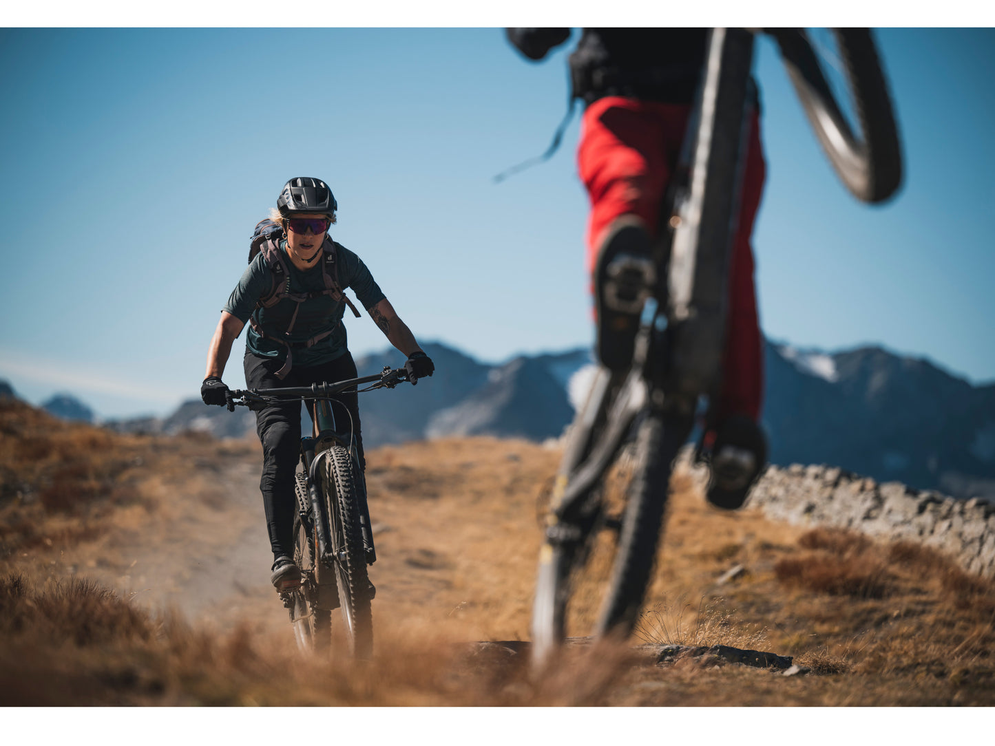 Orbea Rise M-LTD eMTB full suspension two people riding down single track mountains in background