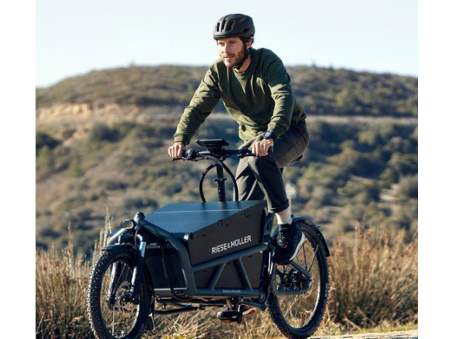 Riese and Muller Load 60 Rohloff HS eMTB full suspension man riding on road in the hills