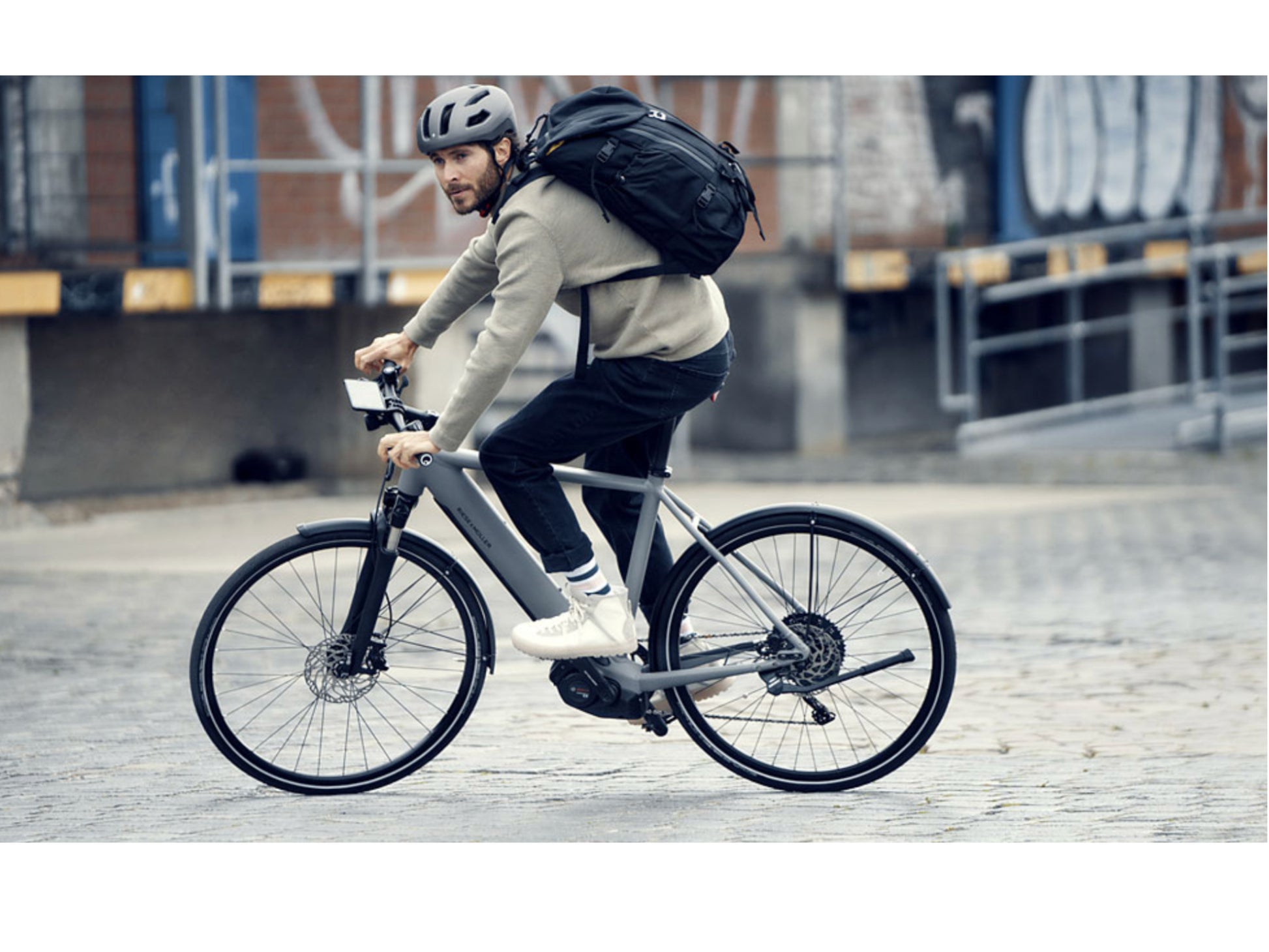 Riese and Muller Roadster Vario eMTB hardtail man touring with backpack smartphone cockpit