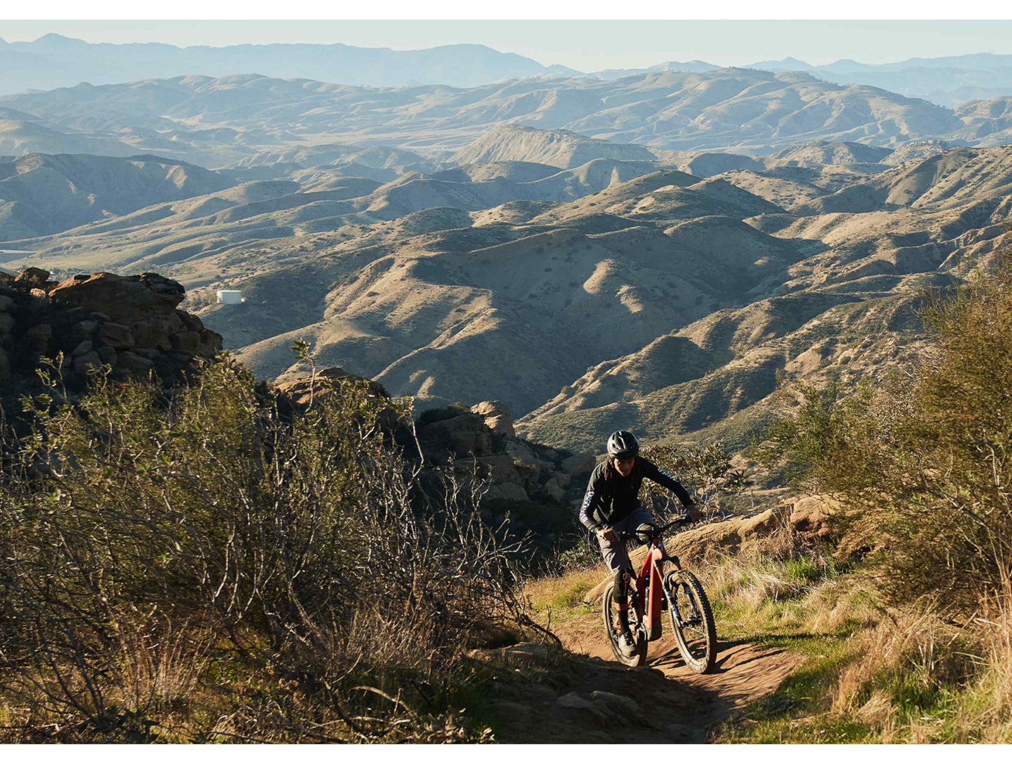 Specialized Turbo Levo Carbon eMtb full suspension rider climbing trail with hills in background