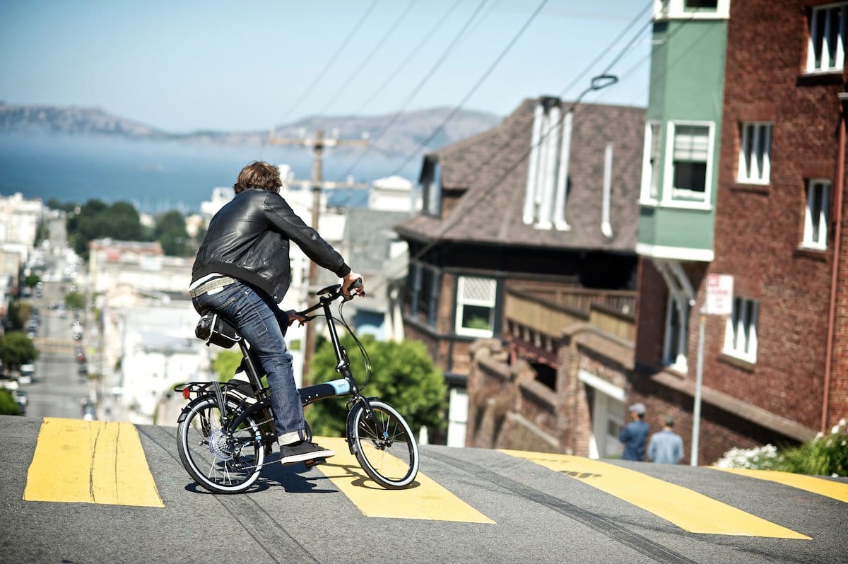 Tern Link folding bike matte black action photo city commute. Man at the top of San Francisco hills
