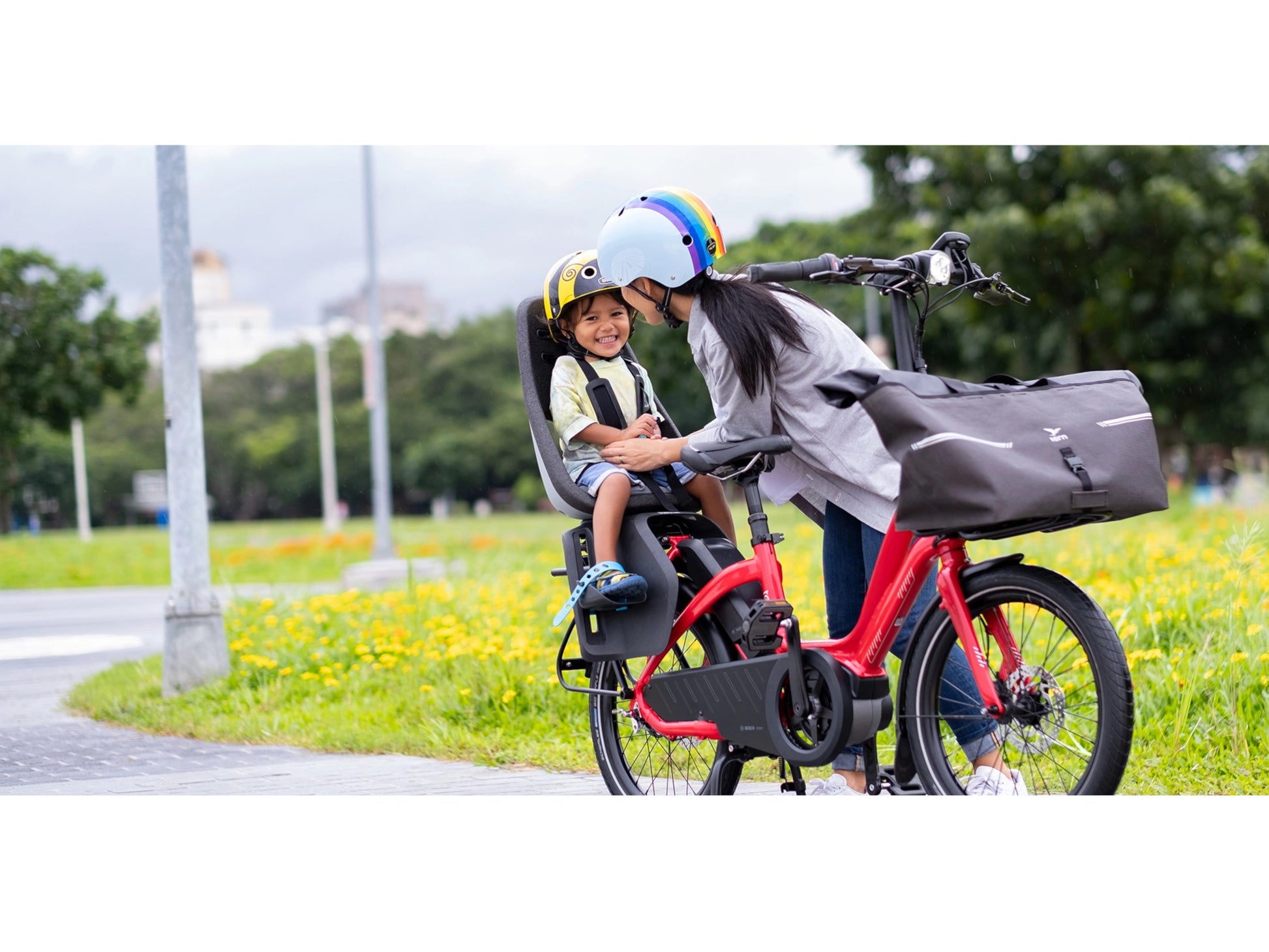 Tern NBD P8i electric cargo bike woman securing child in seat on bike path