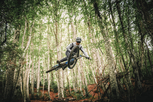 Jumping a Mondraker electric mountain bike in the trees at Fly Rides