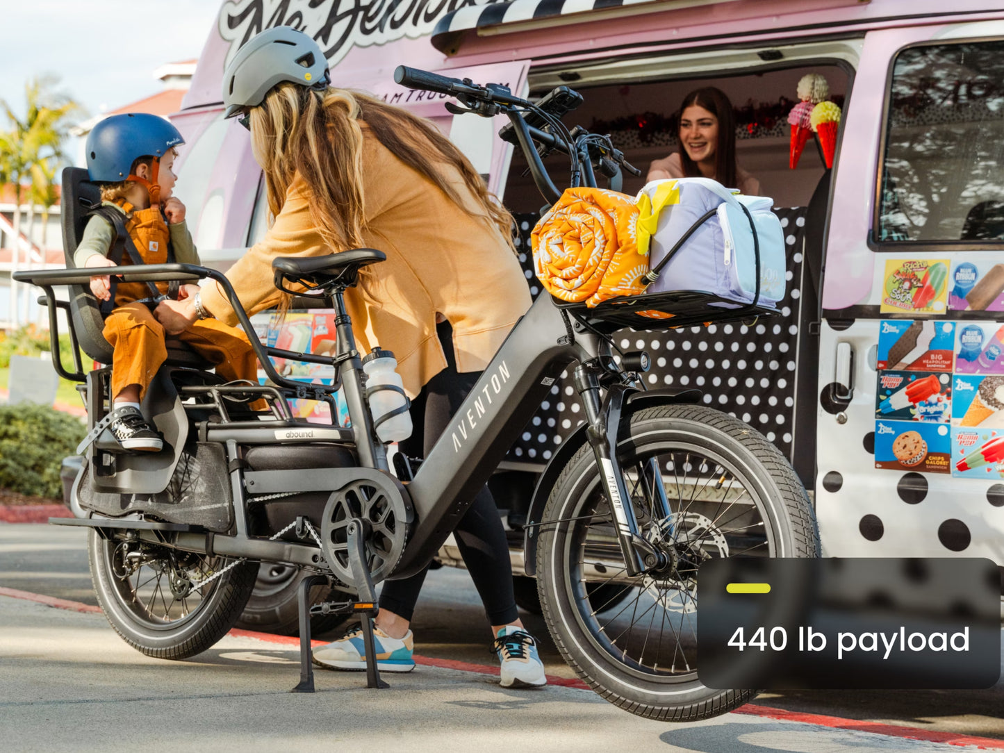 Aventon Abound LR Cargo Electric bike Matte Stealth Cargo set up lifestyle. Mom and kiddo getting ice cream