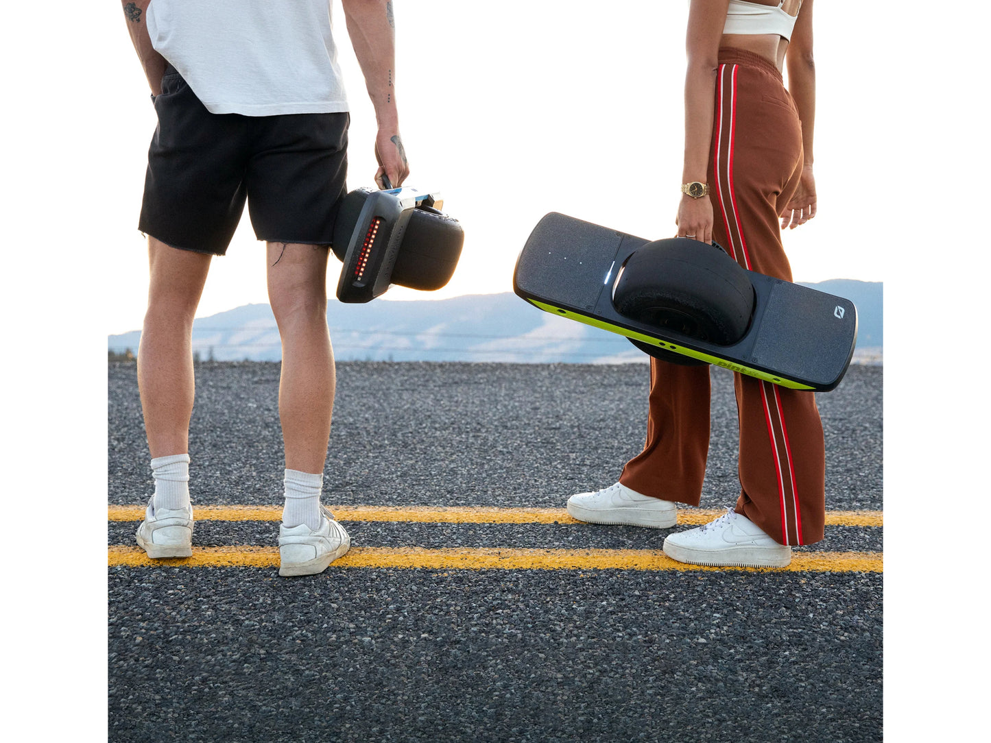 OneWheel Pint X Electric Board Powder blue Guy and Gal riders holding their boards by the integrated handle