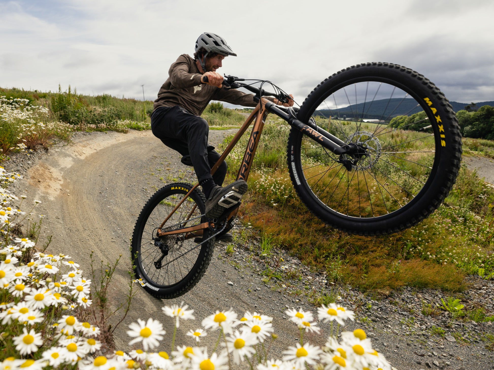 Orbea Laufey Hardtail Mountain bike. Rider pulling a wheelie on a dirt track