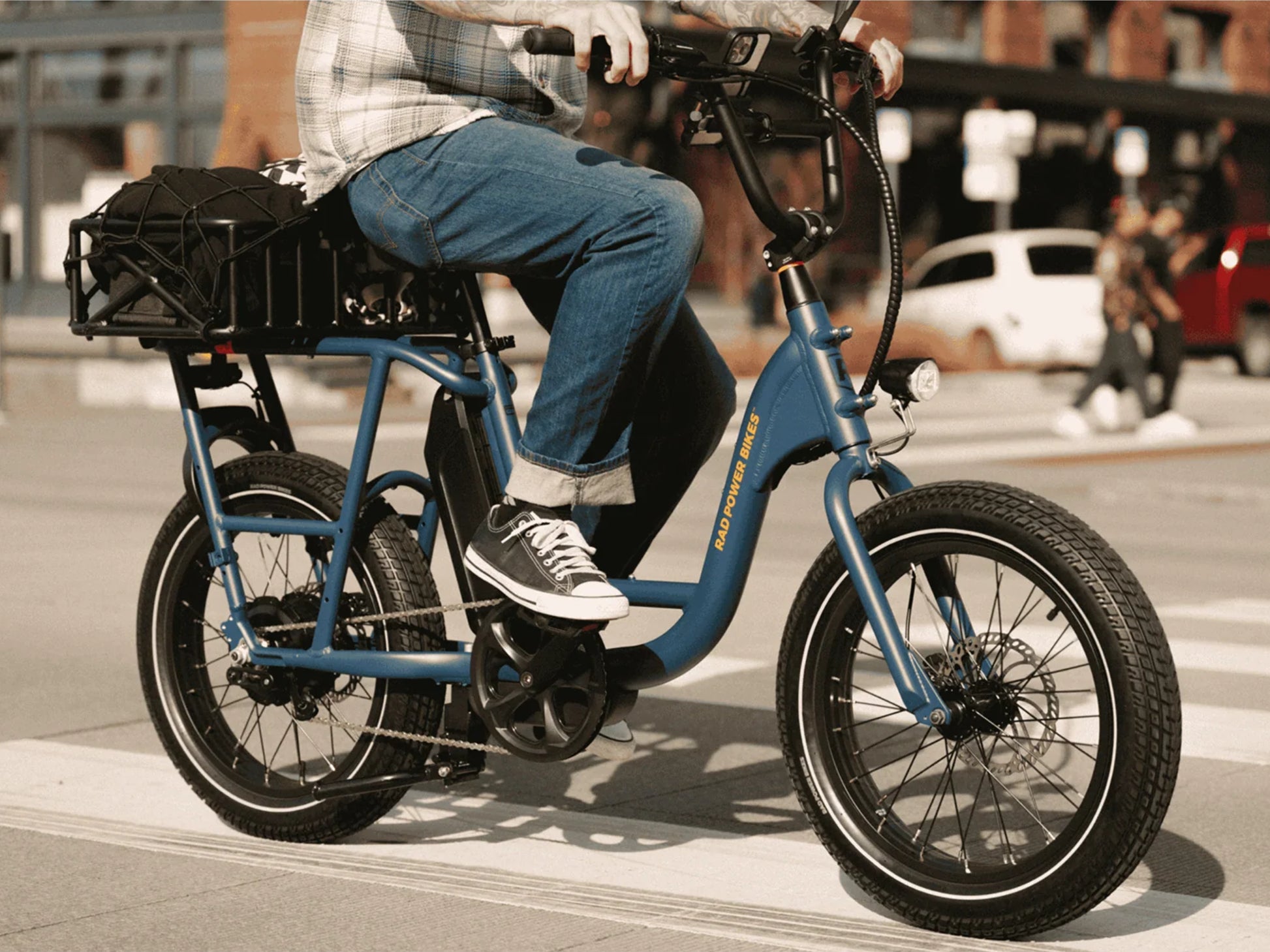 Rad Power RadRunner Electric Cargo Utility Bike Man riding on city street with cargo on rack