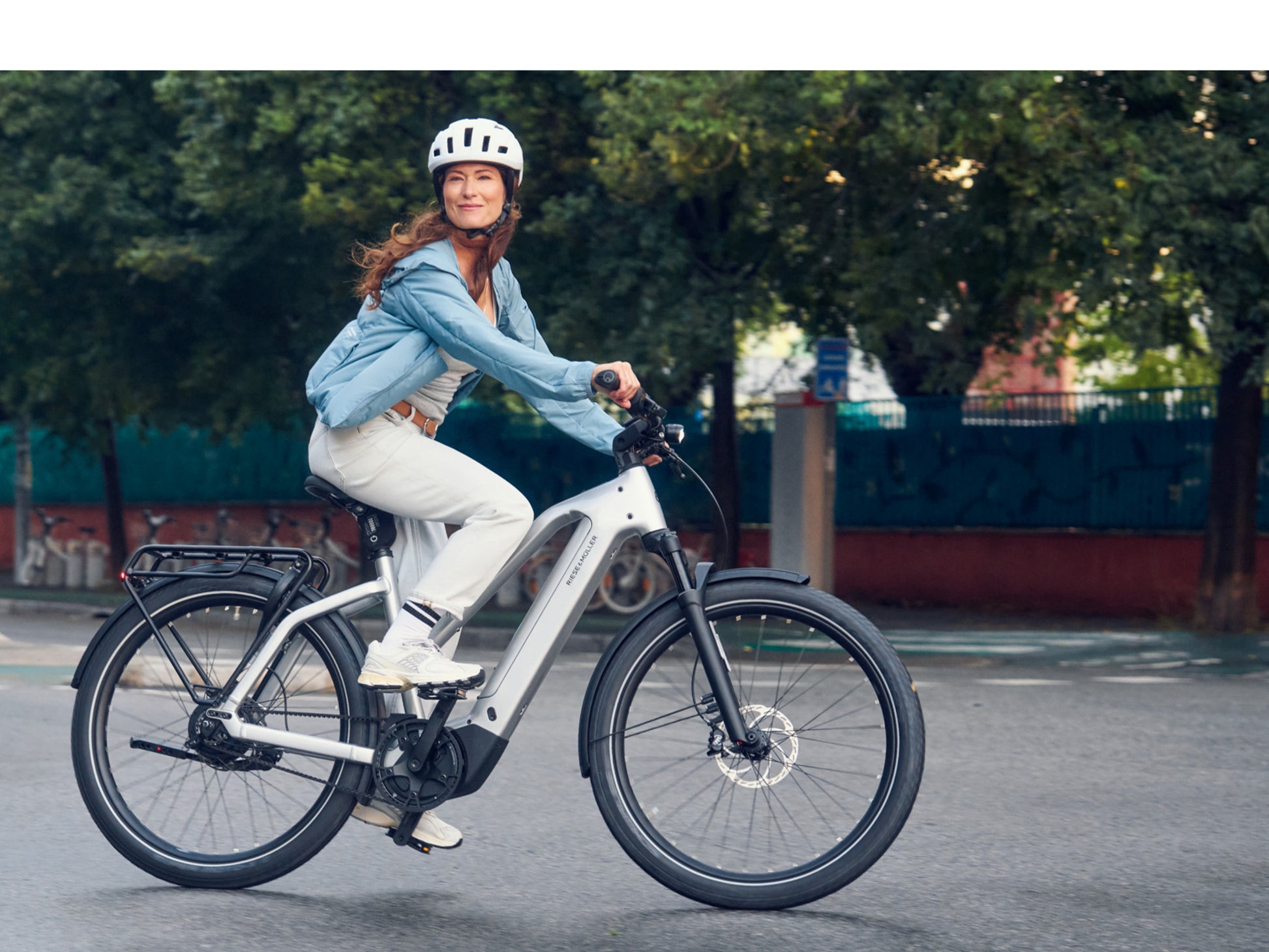Riese & Muller Charger5 Mixte Leisure, Road / Commuter Bosch Woman riding on city steet