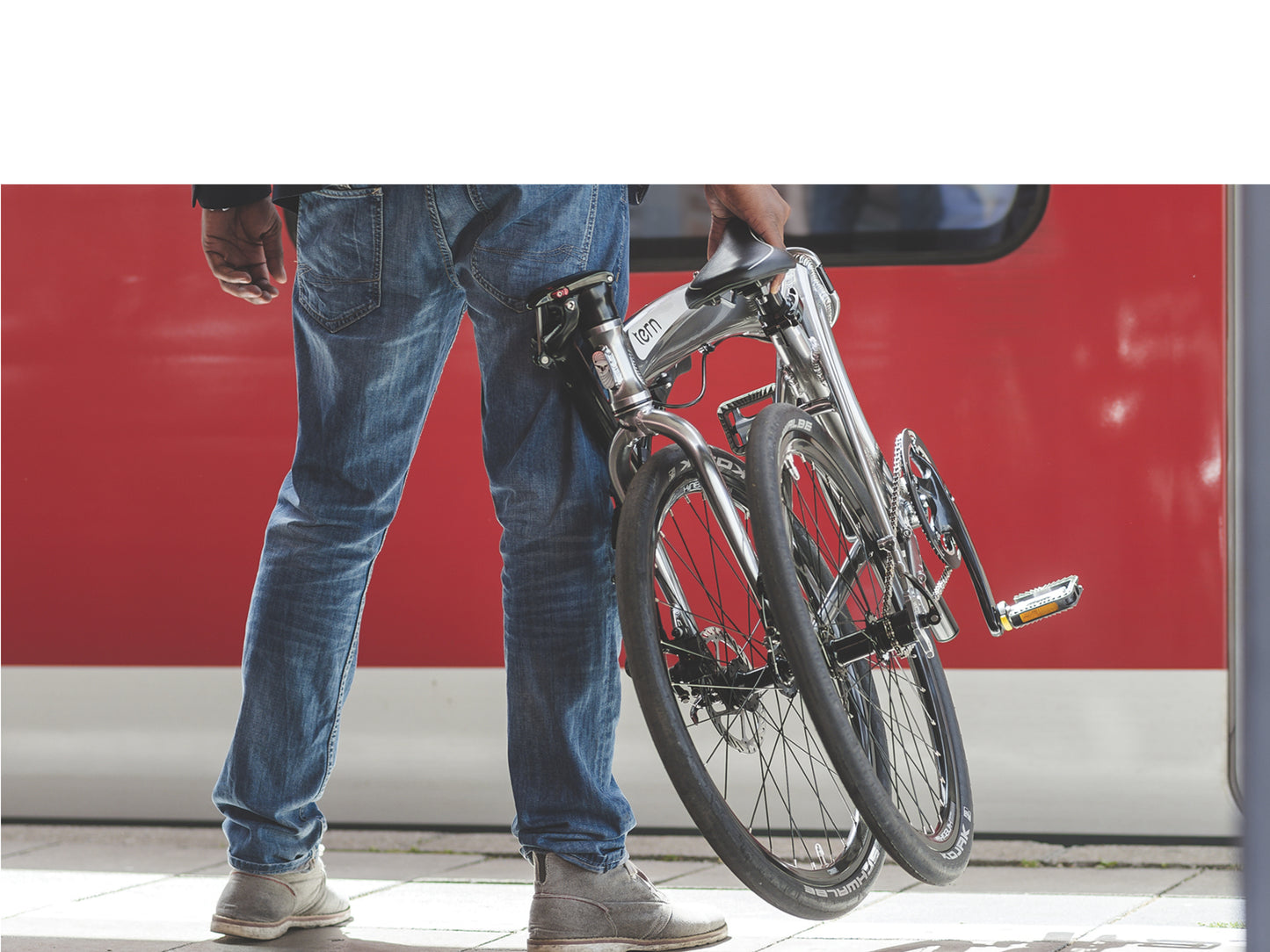 Tern Ecipse folding bike. Man holding a folded bike, waiting for the subway