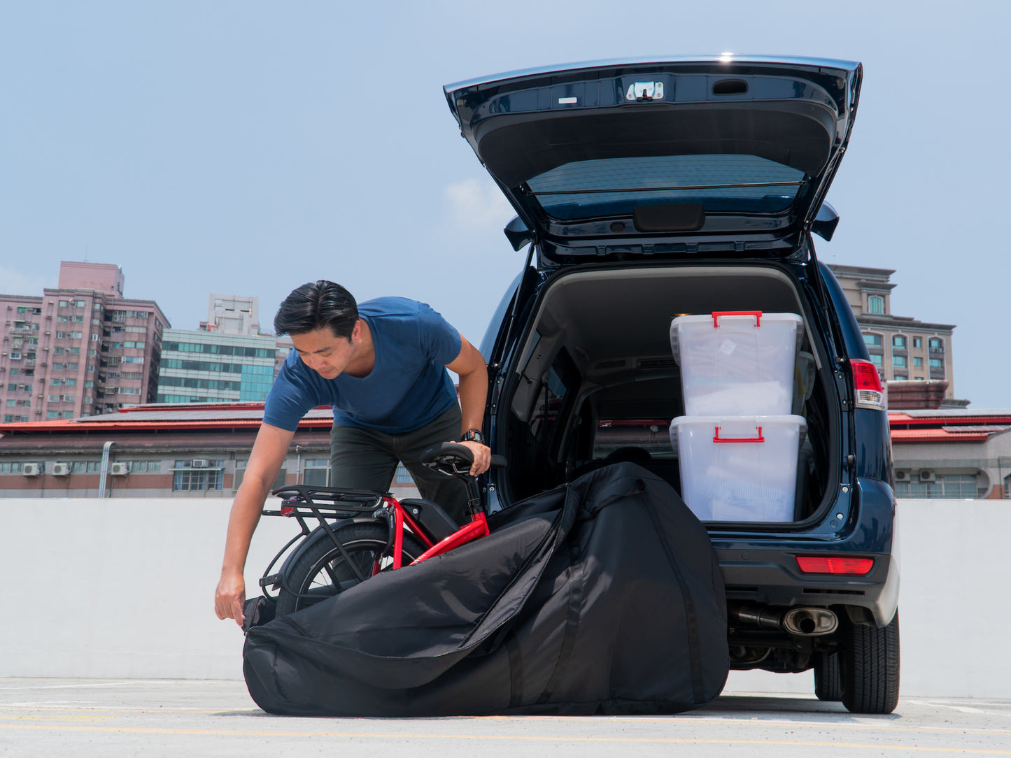 Man opening the Tern FlatFold Bag outside of his SUV