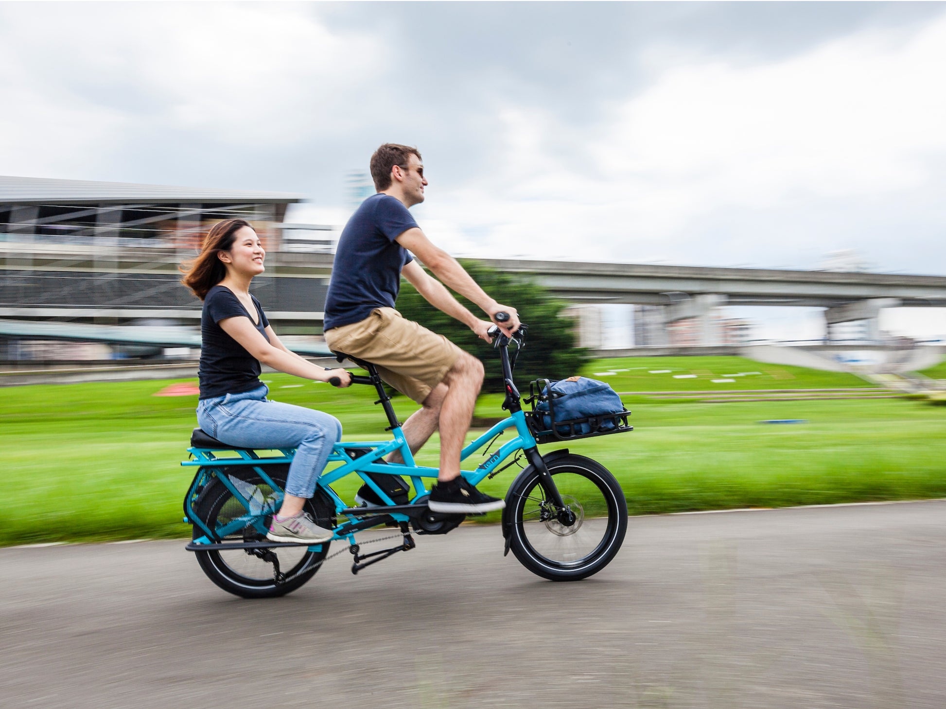 Tern Sidekick Flat Bars Lifestyle. Passenger shown holding Flat bars on a ride with partner in the city