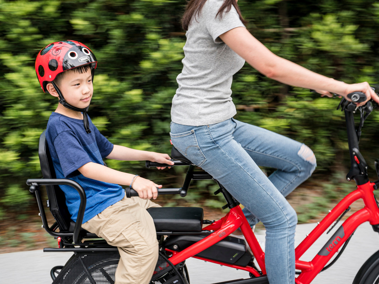 Tern Sidekick Joyride bars. Lifestyle with child holding the Joyride bars on a ride with mom